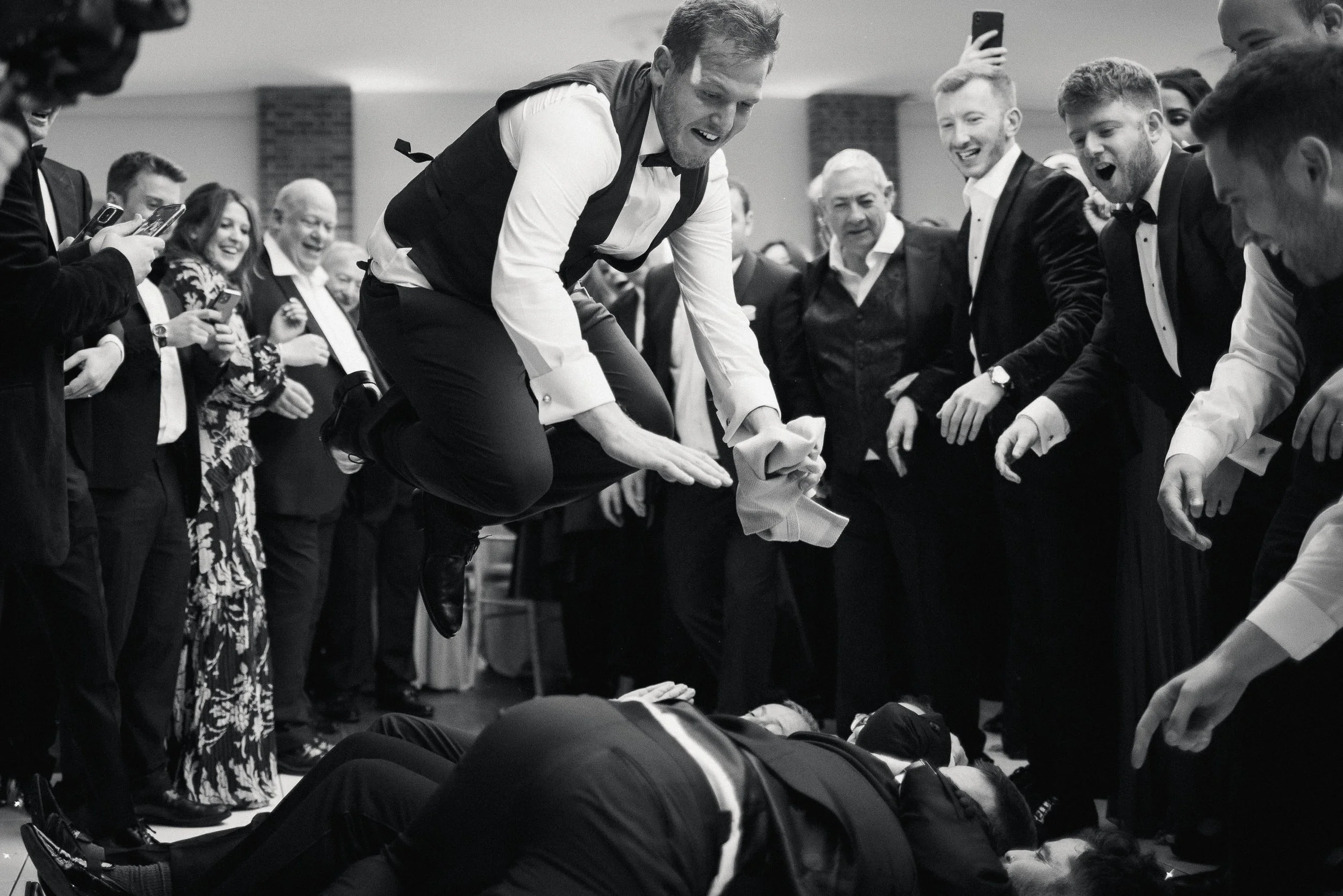 Jewish jumping over wedding guests during the wedding reception celebrations at Offley Place.