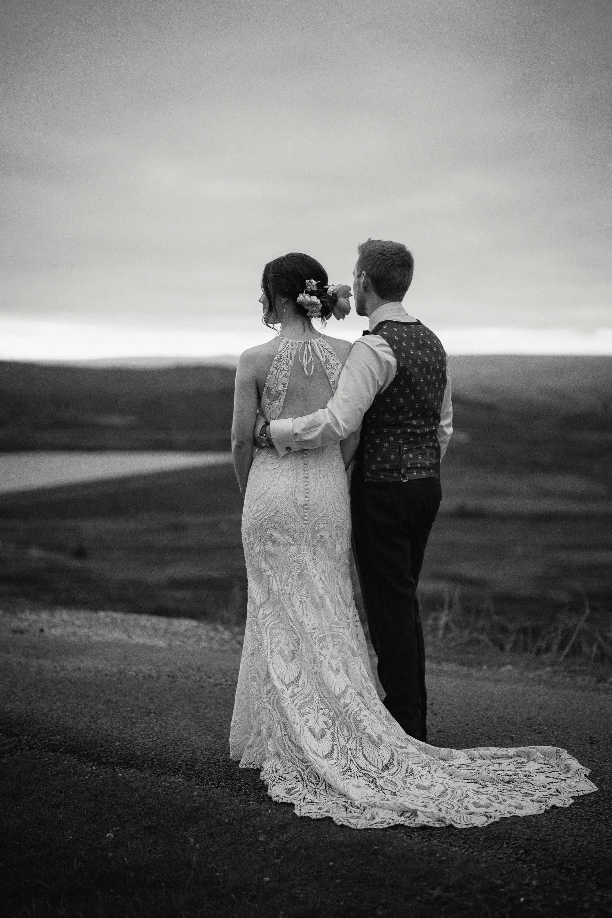 Black and white photo of bride and groom standing arm in arm overlooking the Yorkshire Moors at The Priest’s House, captured during their wedding at sunset.