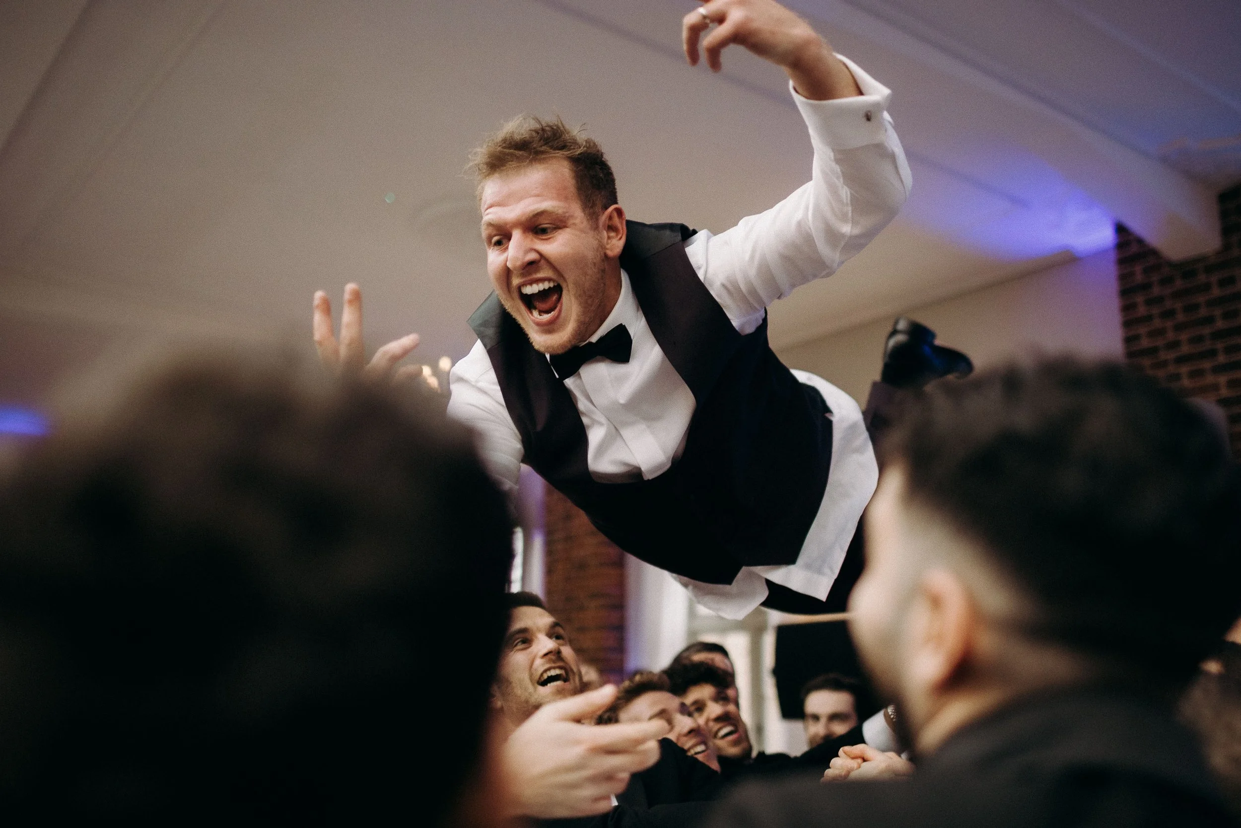 Jewish groom gets thrown into the air by guests during the wedding reception at Offley Place.