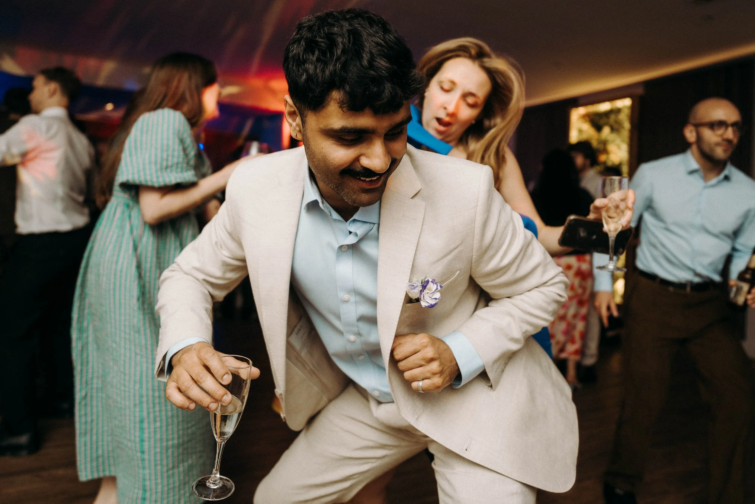 Wedding guest in a suit dancing with a lady behind him during the wedding reception at Two Woods Estate.