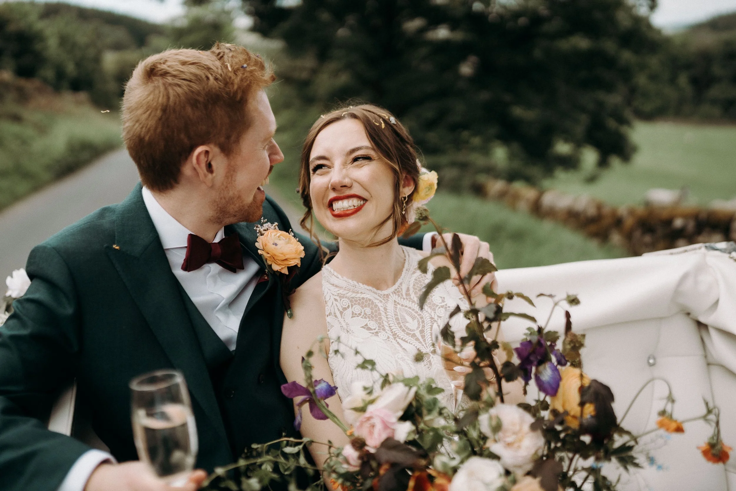 Bride and groom sitting in a carriage and laughing together after their ceremony at The Priest’s House.