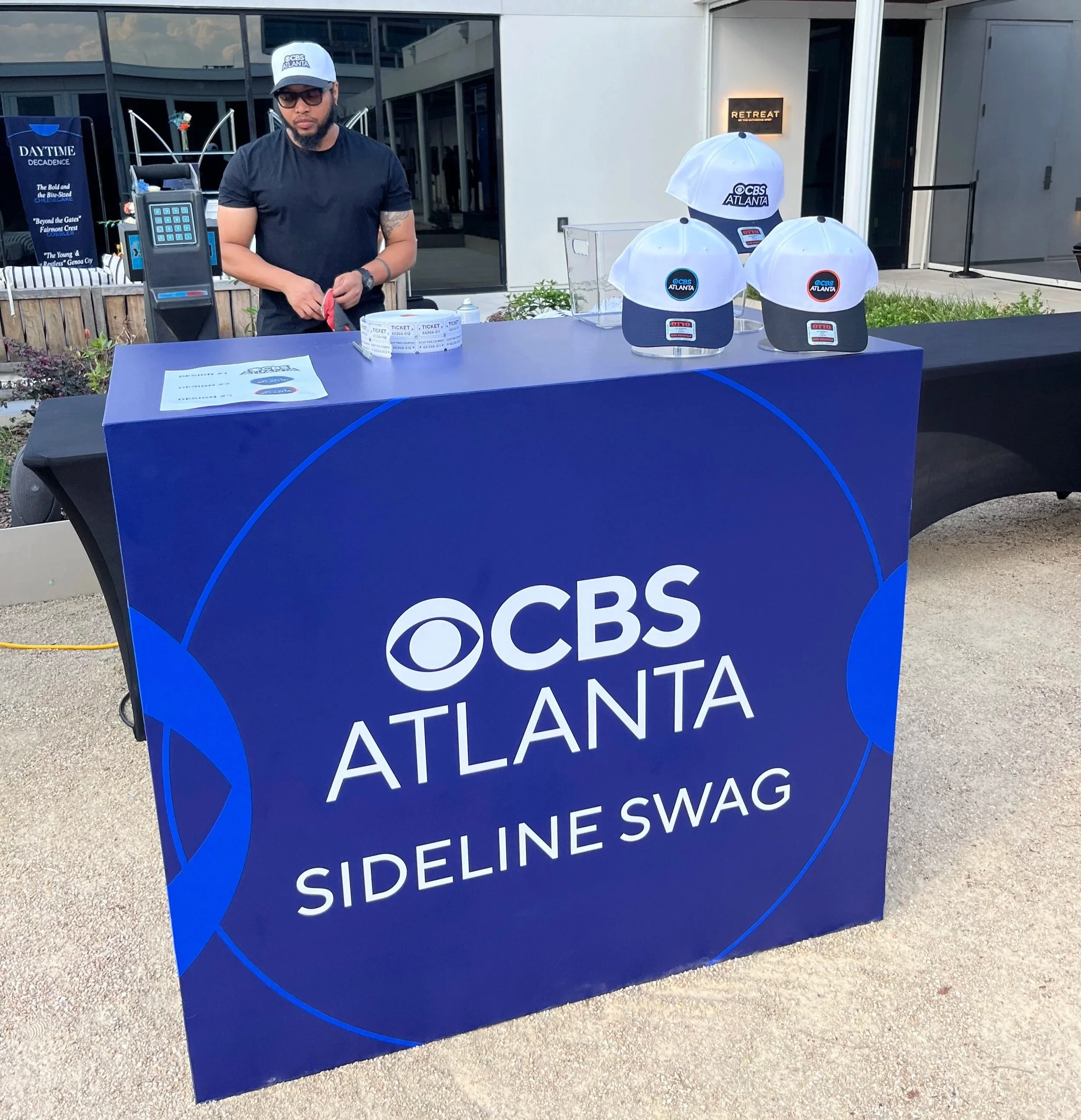 Custom CBS Atlanta Sideline Swag station booth setup featuring branded hats display at an event.