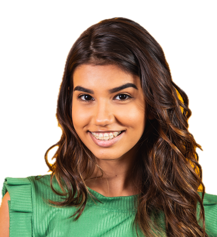 A woman with long, wavy brown hair wearing a green top and smiling at the camera.