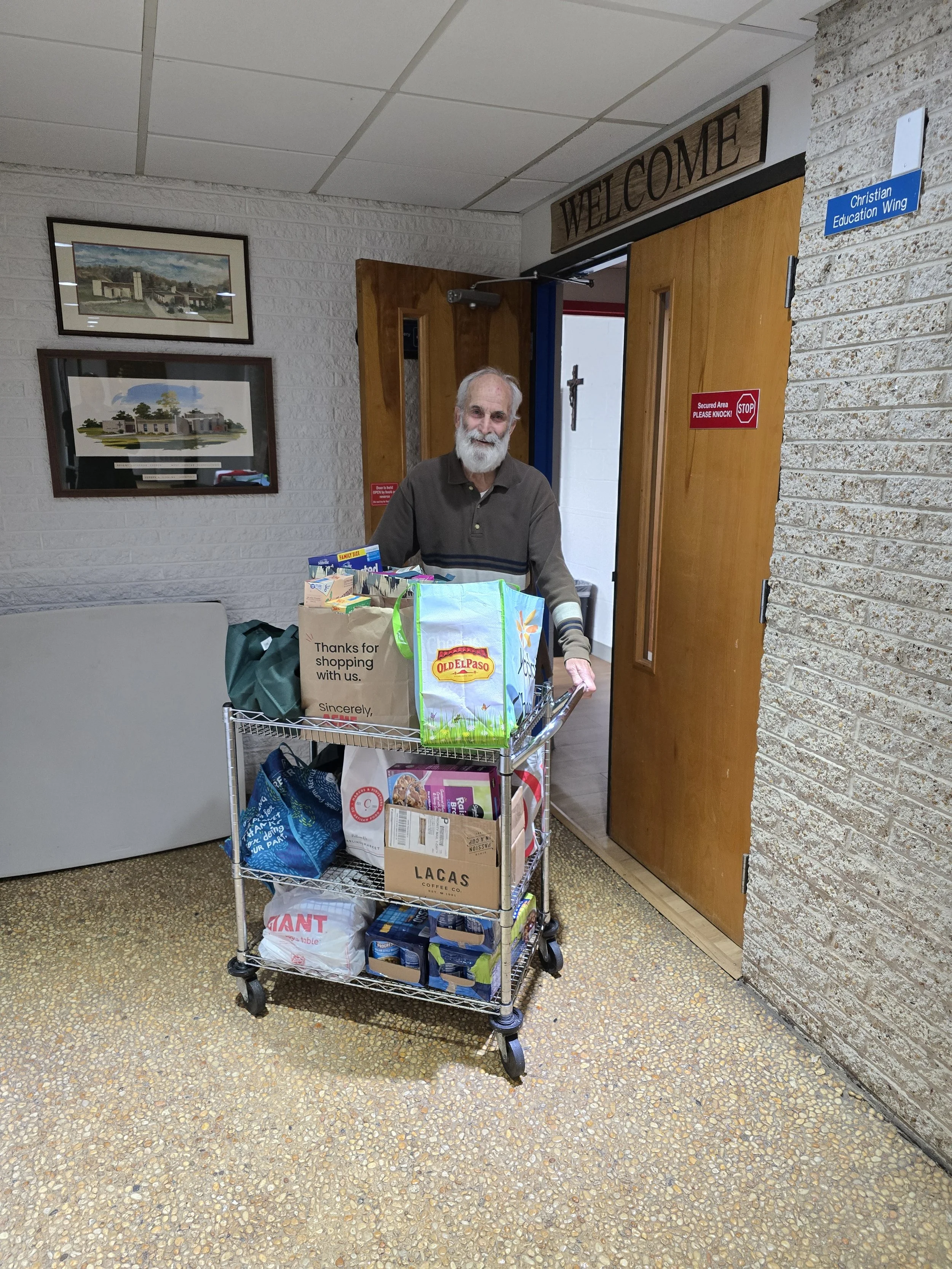 Man with a cart full of nonperishable food items for the West Chester  food bank