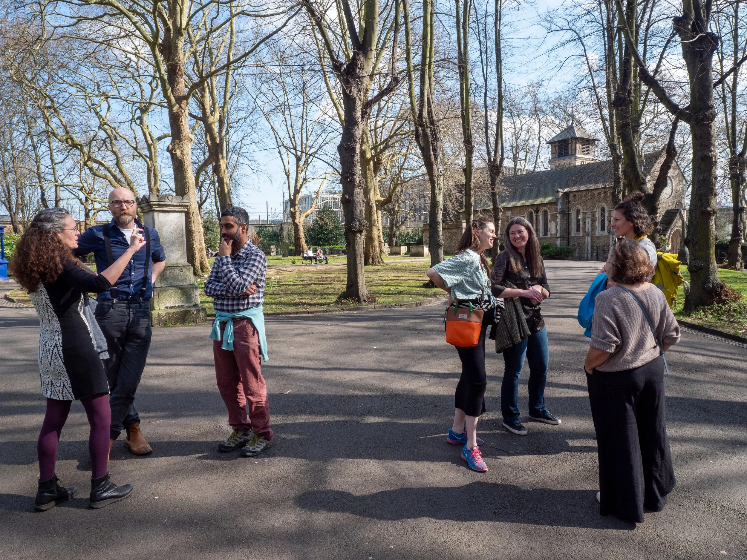 WAI grantees stand outside in two small groups, talking and smiling.