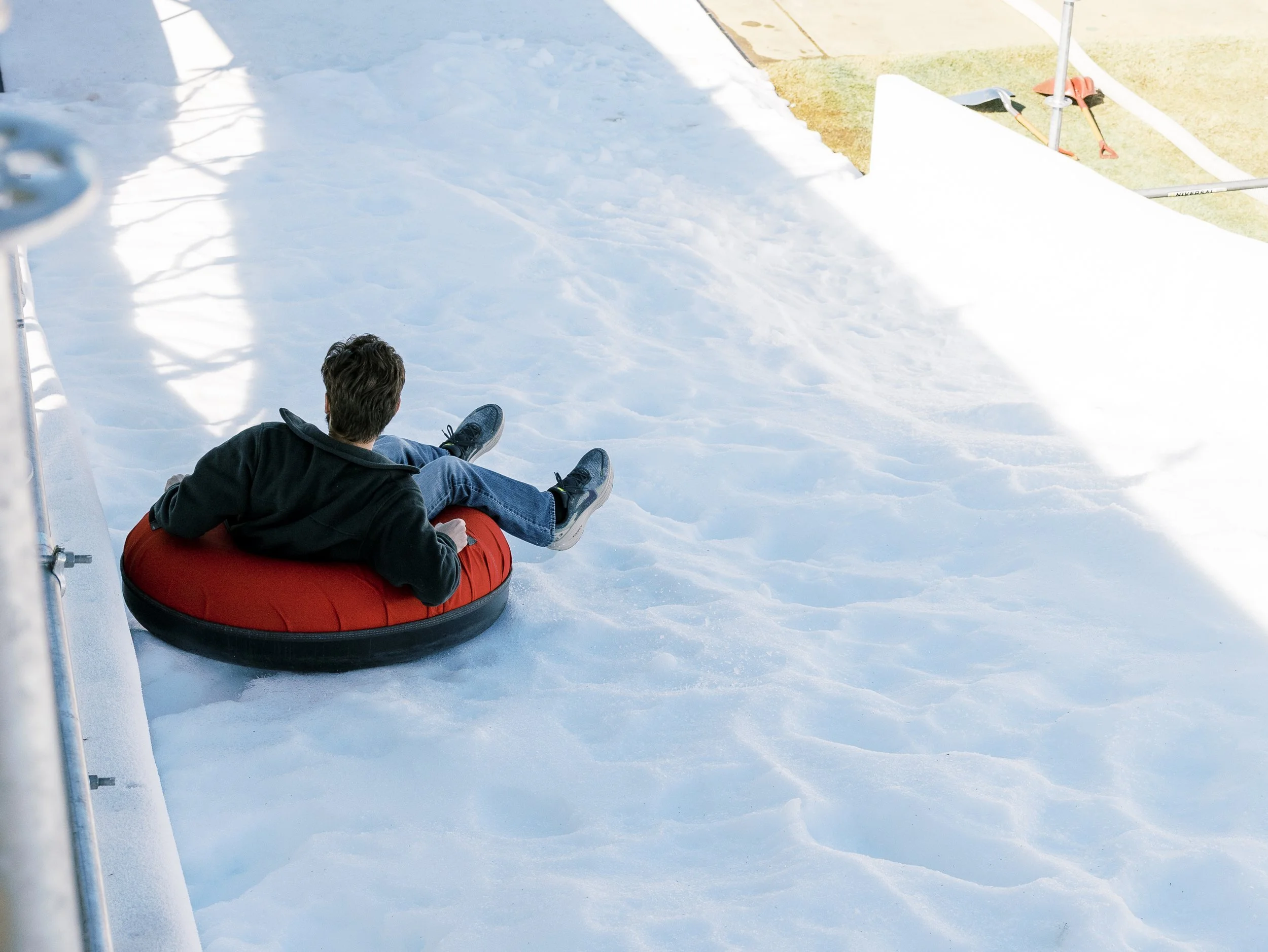 a person riding a snow tube down the snow slide