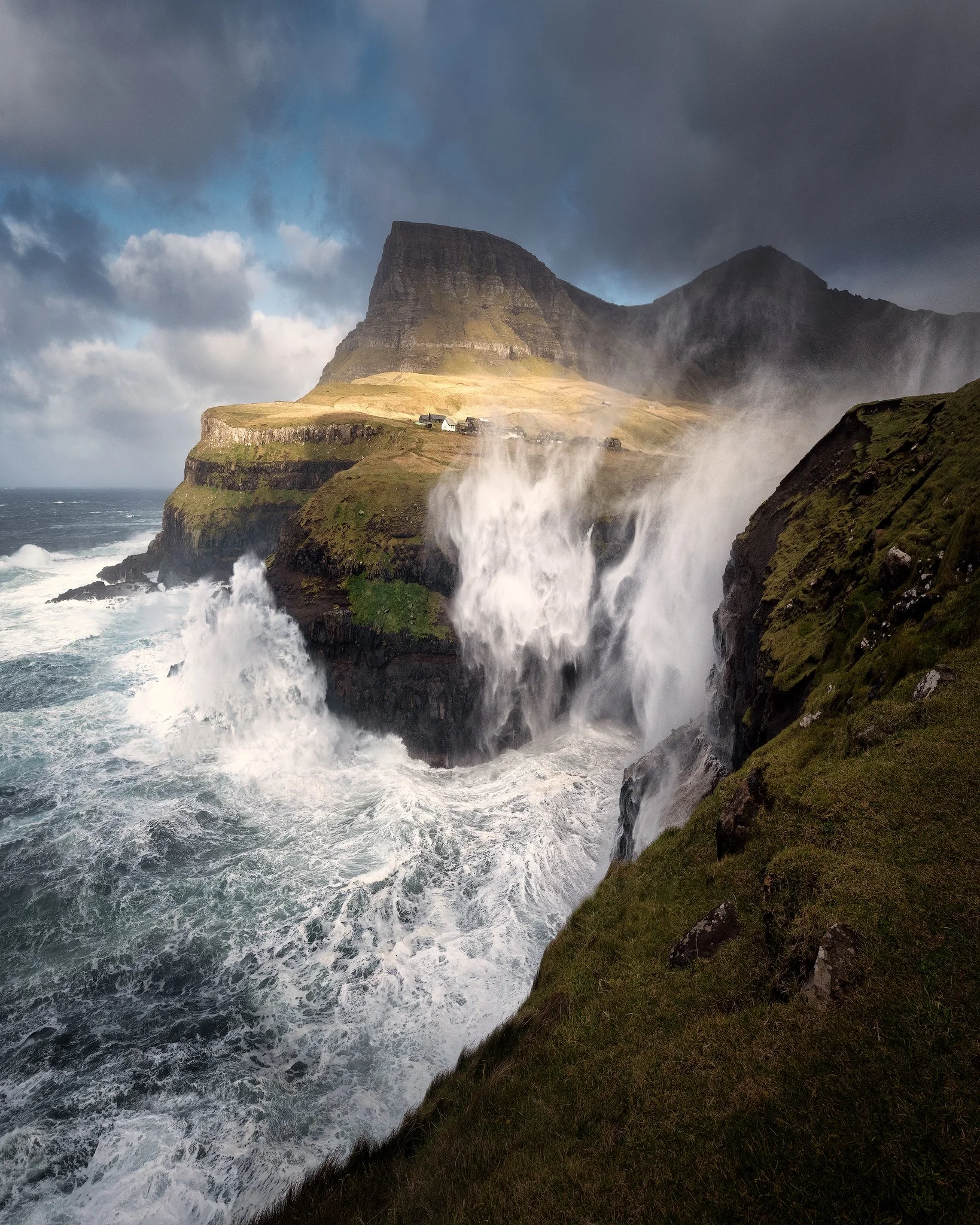 Storm waves crashing below Múlafossur waterfall at Gásadalur in wild weather, Faroe Islands
