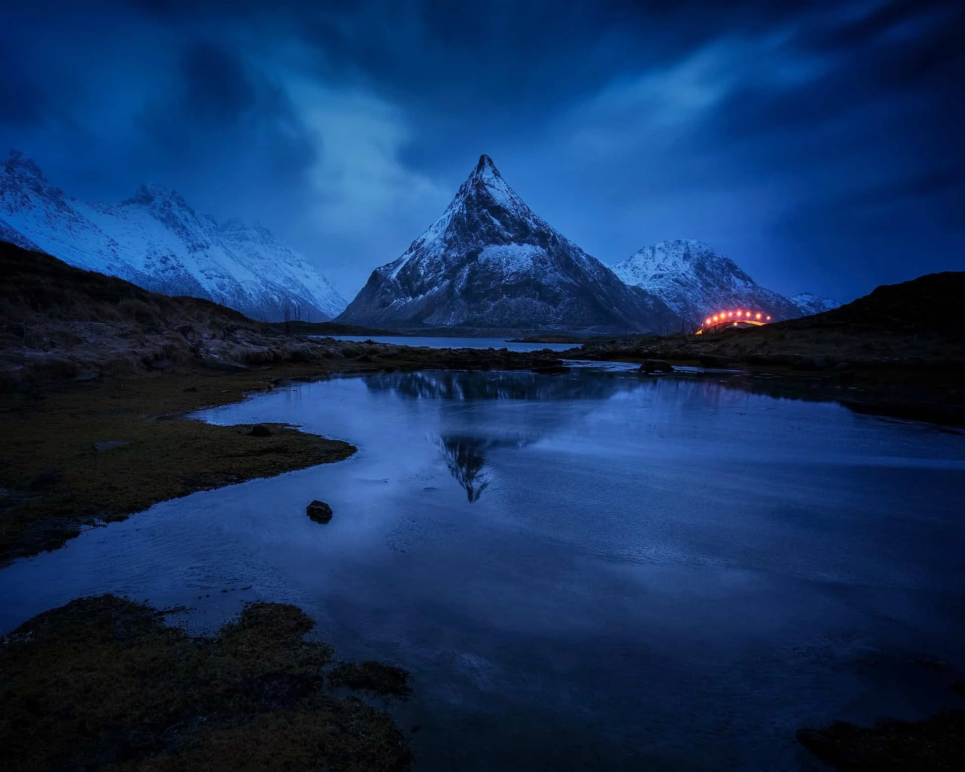 Fredvang bridges leading toward snow-covered peaks in winter, Lofoten, Norway