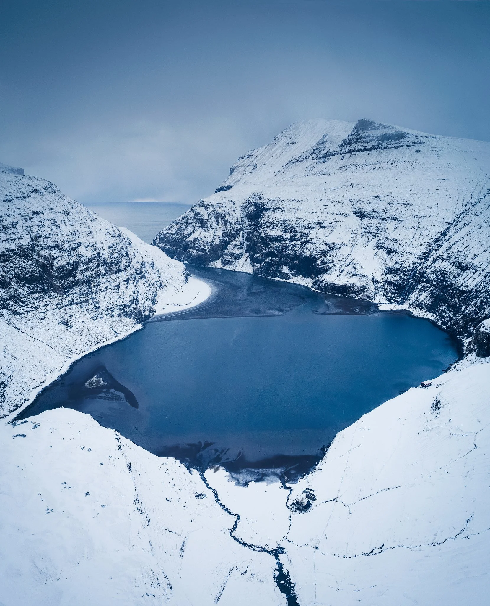 Aerial view of Saksun village and its tidal lagoon in winter, Faroe Islands