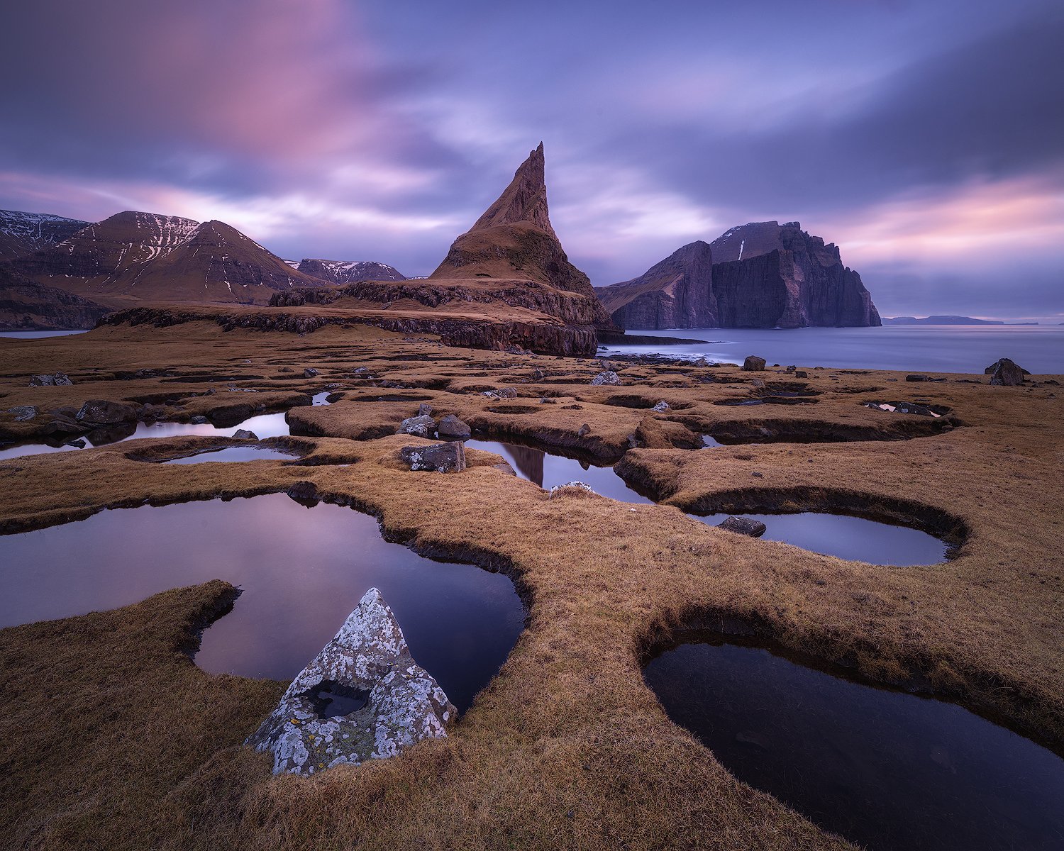 Tindhólmur islet at sunset with tidal pools in the foreground, Faroe Islands