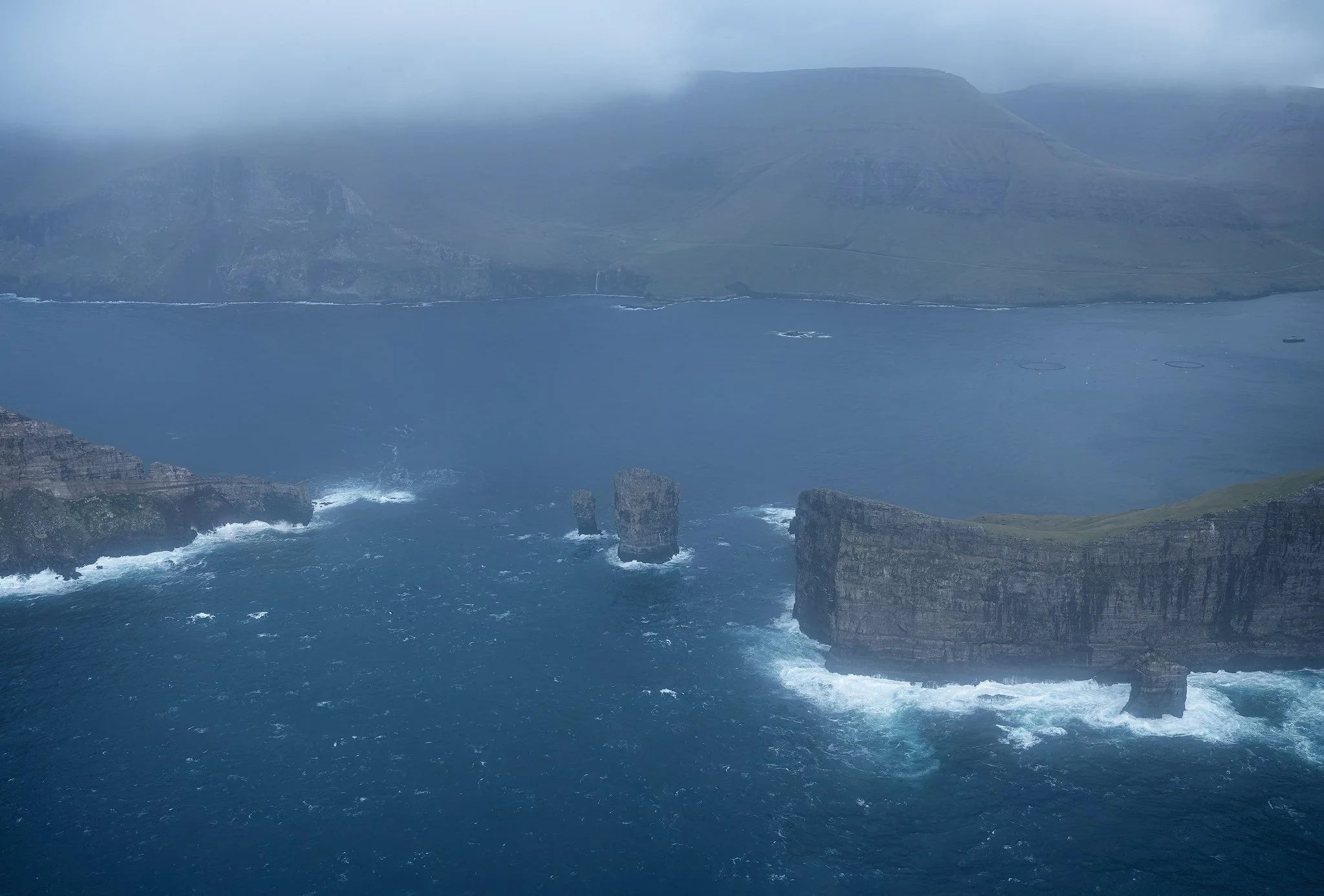 Aerial view of Drangarnir sea stacks and arch with Tindhólmur beyond, Faroe Islands