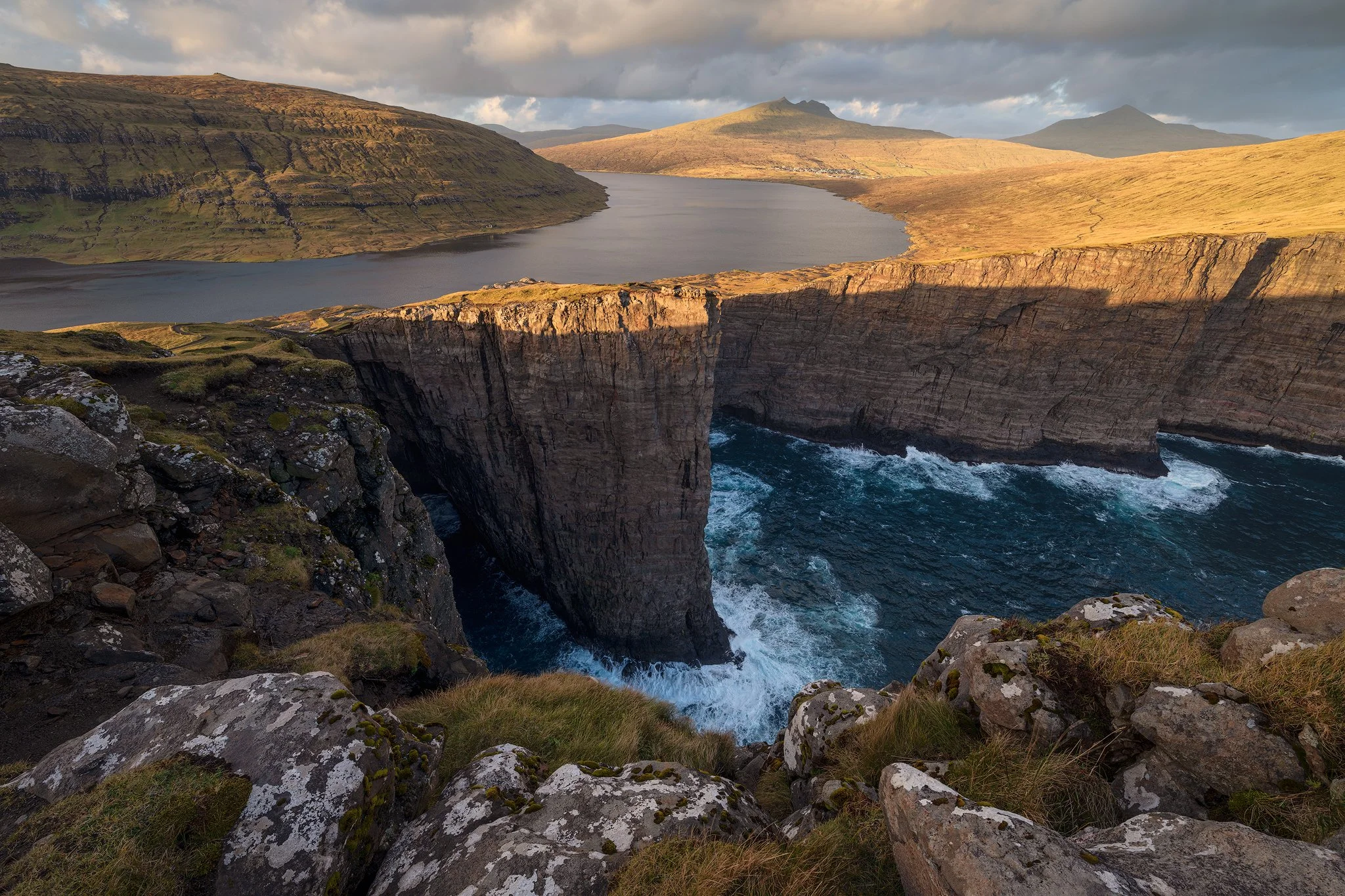 Sørvágsvatn lake appearing to float above the ocean at sunset from Trælanípa, Faroe Islands