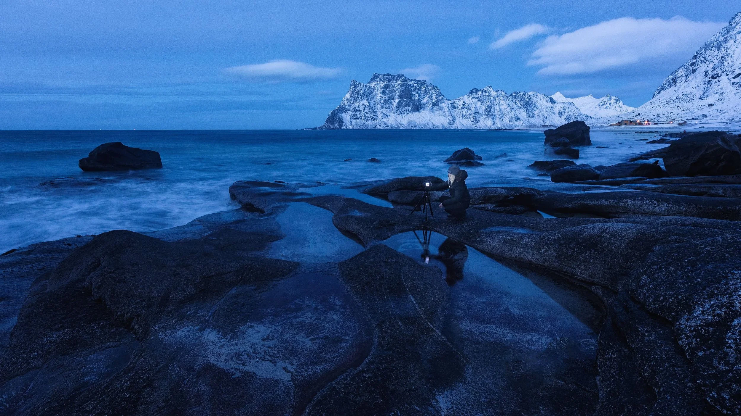 Photographer shooting the gorgeous twilight of the arctic winter at Utakleiv beach on Lofoten islands in northern Norway