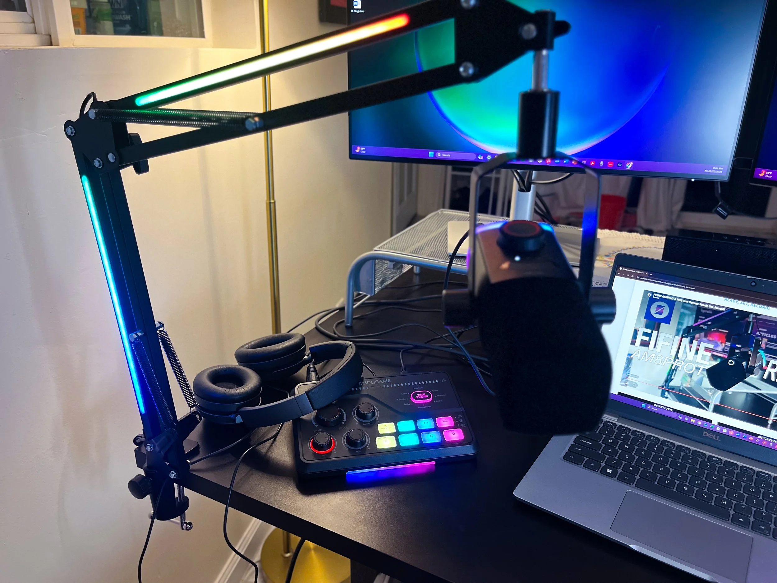 Image of a FIFINE microphone, laptop and mixer on a desk in a review by The Sypnotix