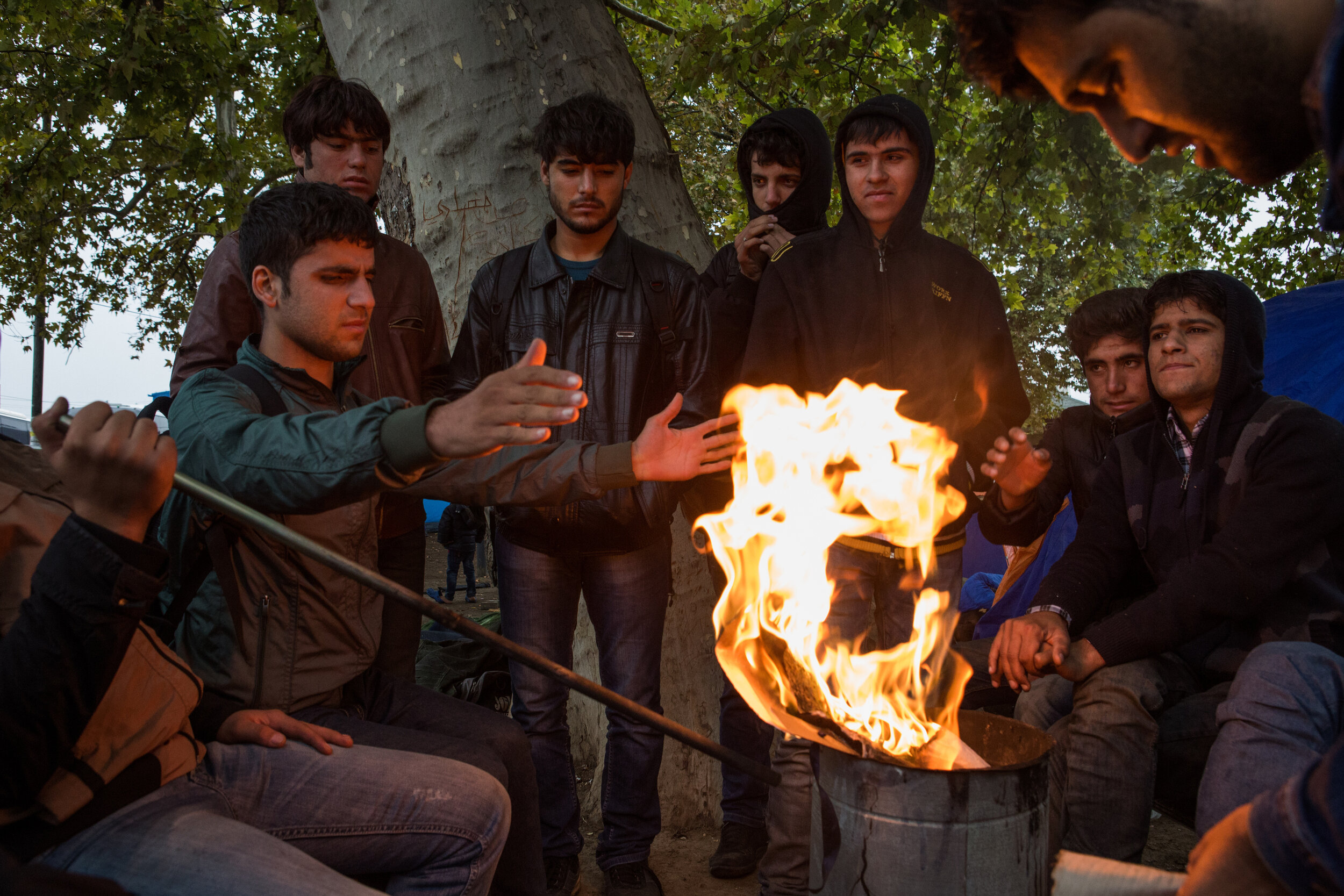  A group of refugees from Afghanistan warm-up at a park located next to the central bus station in Belgrade, Serbia, before continuing north to Hungary. Most refugees arrive to Belgrade by bus from the southern border with Macedonia. Until mid-Septem