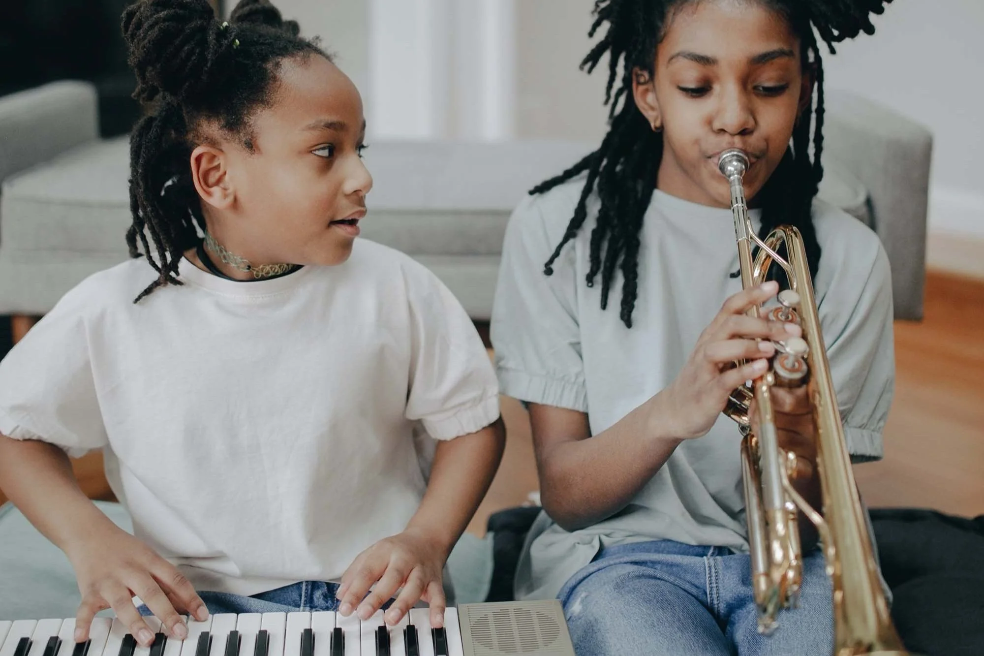 two siblings playing musical instruments at home