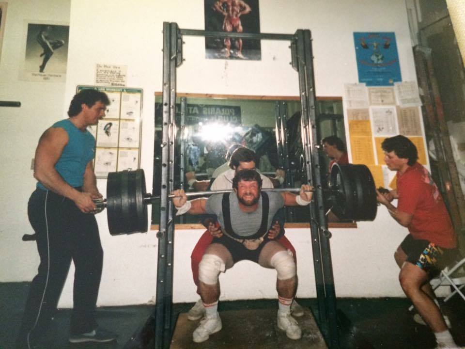 Bill Frick, owner of Polaris Athletic Club, squatting inside the original Polaris gym in Anchorage, Alaska.