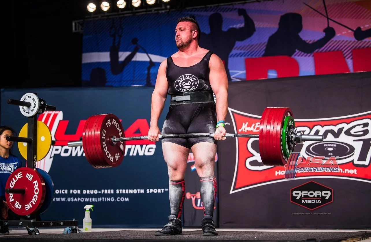 Southside champion powerlifter Dr. Jake Rammell, DC, standing on the competition platform during a meet.