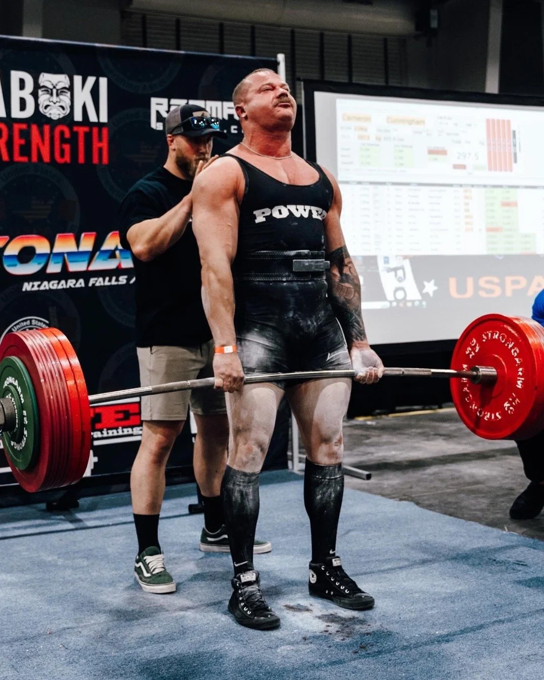 Southside athlete Cameron competing in a powerlifting event, performing a heavy deadlift on stage during a sanctioned meet