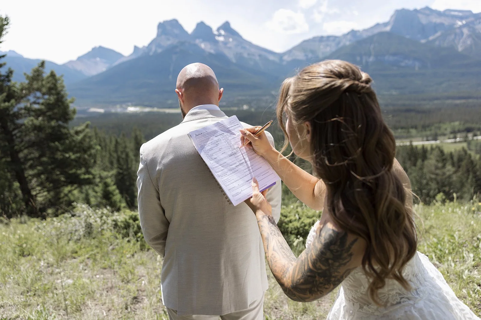signing-a-marriage-certificate-in-the-mountains-photographed-by-Canmore's-local-elopement-photographers-Wild-Alpine-Image-Co.