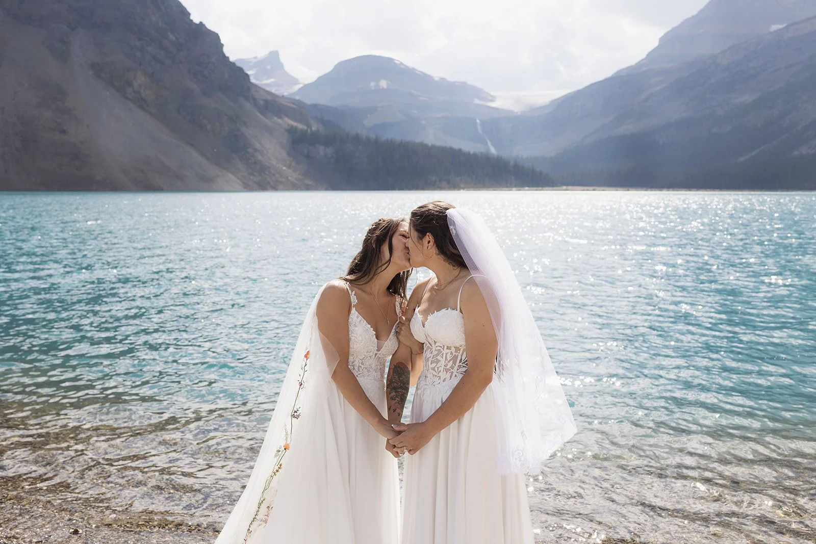 two-brides-share-a-first-kiss-at-Bow-Lake-during-their-elopement-in-Banff-National-Park-photographed-by-Banffs-local-LGBTQ+-elopement-photographers-Wild-Alpine-Image-Co.
