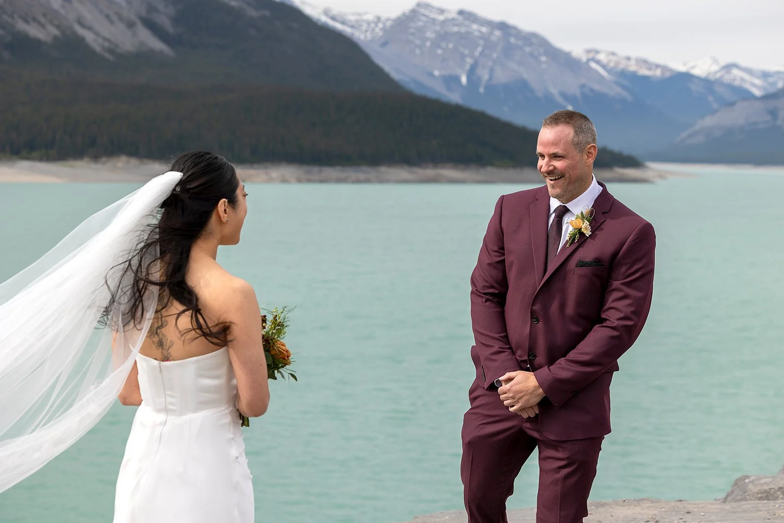 first-look-at-abaraham-lake-before-their-heli-elopement-on-a-dramatic-cliff-in-banff-with-Wild-Alpine-Image-Co.-Banff's-best-elopement-photographers