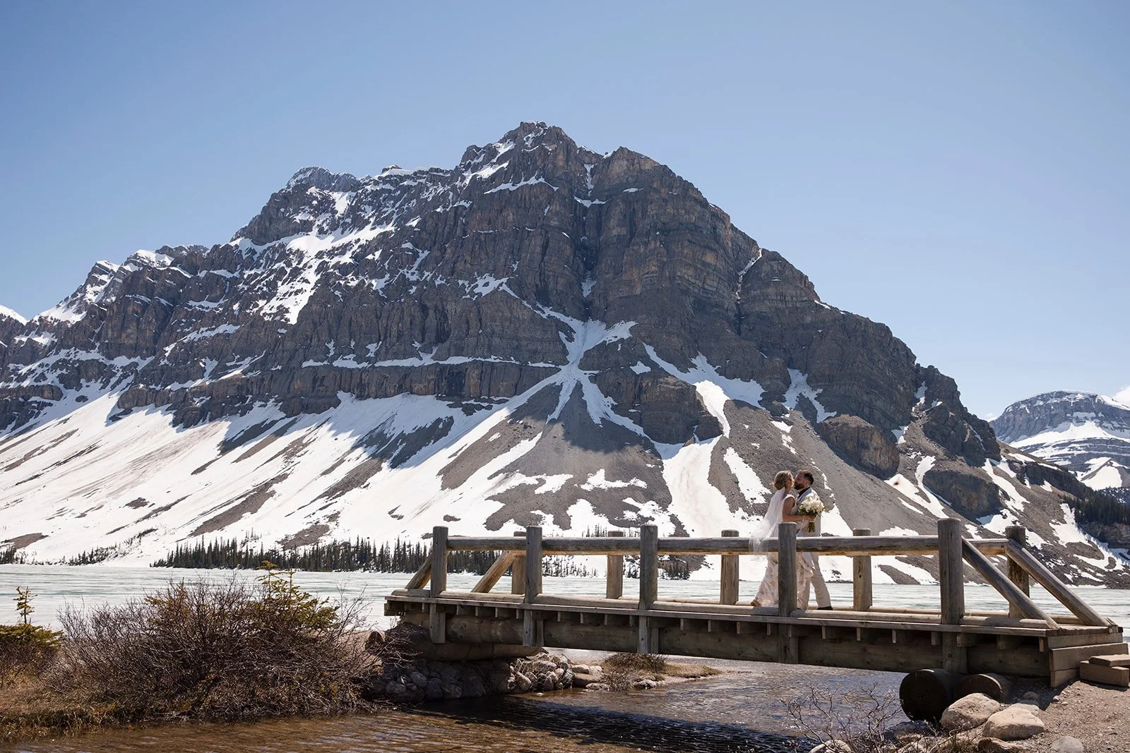 wedding-photos-on-the-bridge-at-bow-lake-with-Wild-Alpine-Image-Co.-Banff's-bespoke-elopement-experts