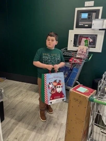 Child holding a Christmas gift they're donating to Kids Inspire Christmas Appeal through Dunelm's delivering joy.