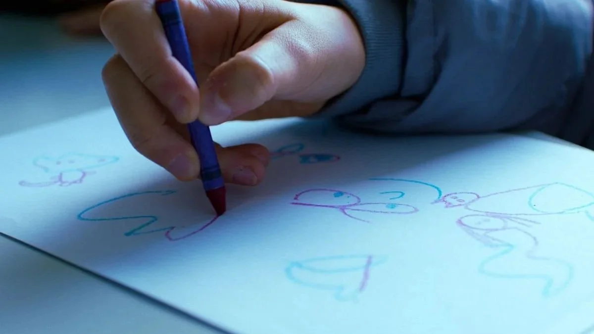 Close up of child hand drawing during creative therapy at Kids Inspire