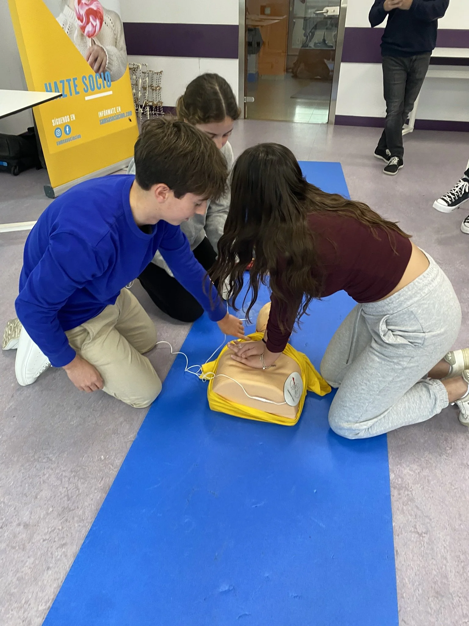 Foto de dos jovenes practicando maniobras RCP a un muñeco de pruebas