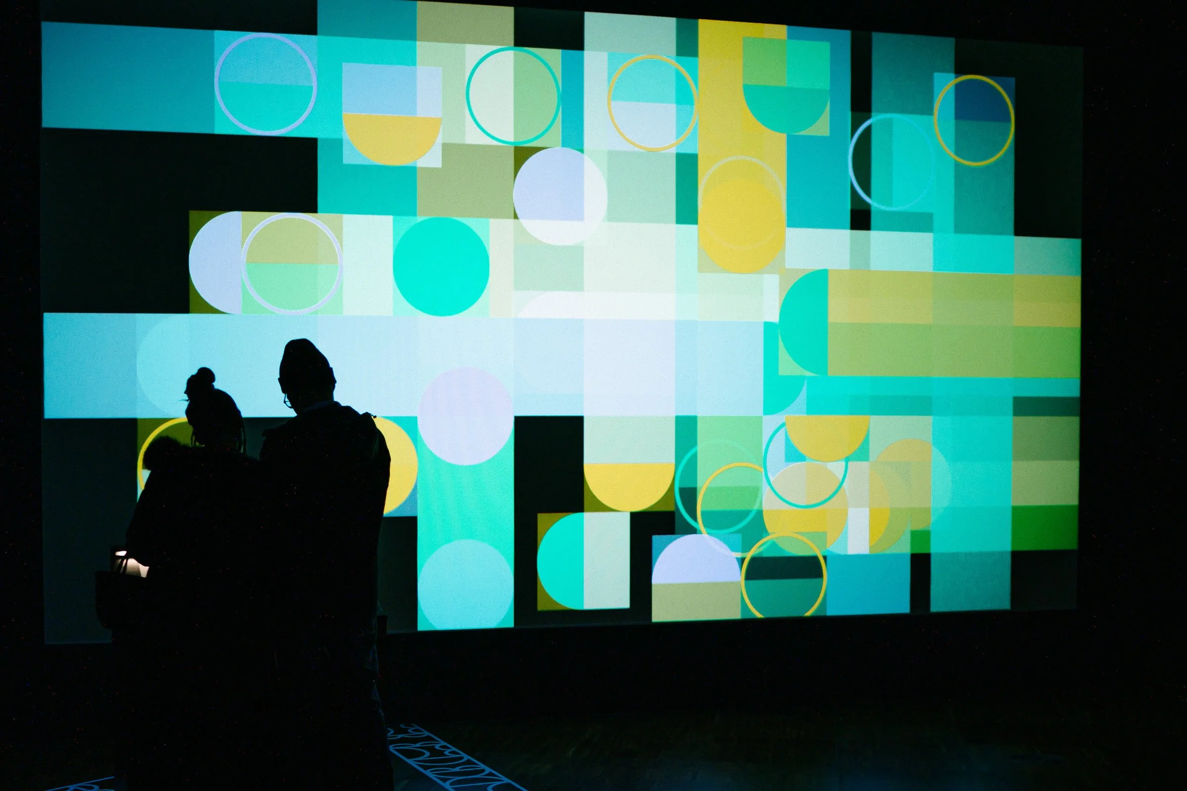 Visitors creating collaborative digital paintings as part of shemza.digital #4–7, with their artworks appearing live on the gallery projection.