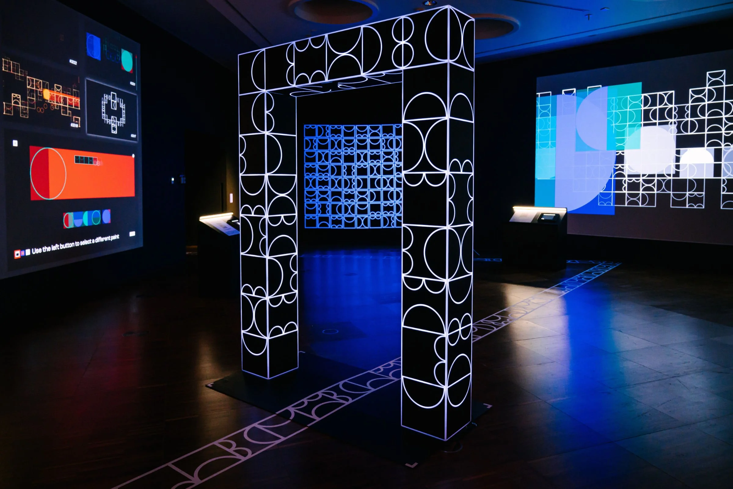 Gallery installation view of shemza.digital #5, an interactive illuminated archway inspired by Anwar Jalal Shemza's City Walls series.