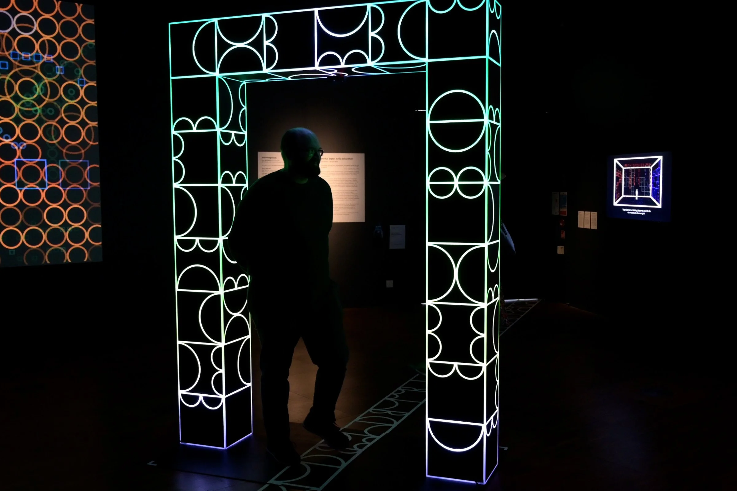 Visitor activating shemza.digital #5, as the illuminated archway glows green in response to movement.