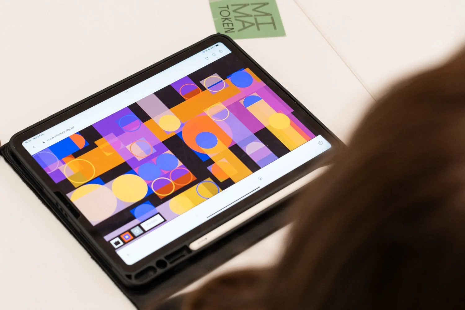 Visitor creating colourful geometric digital artwork using the shemza.digital app on an iPad during a participatory workshop at MIMA.