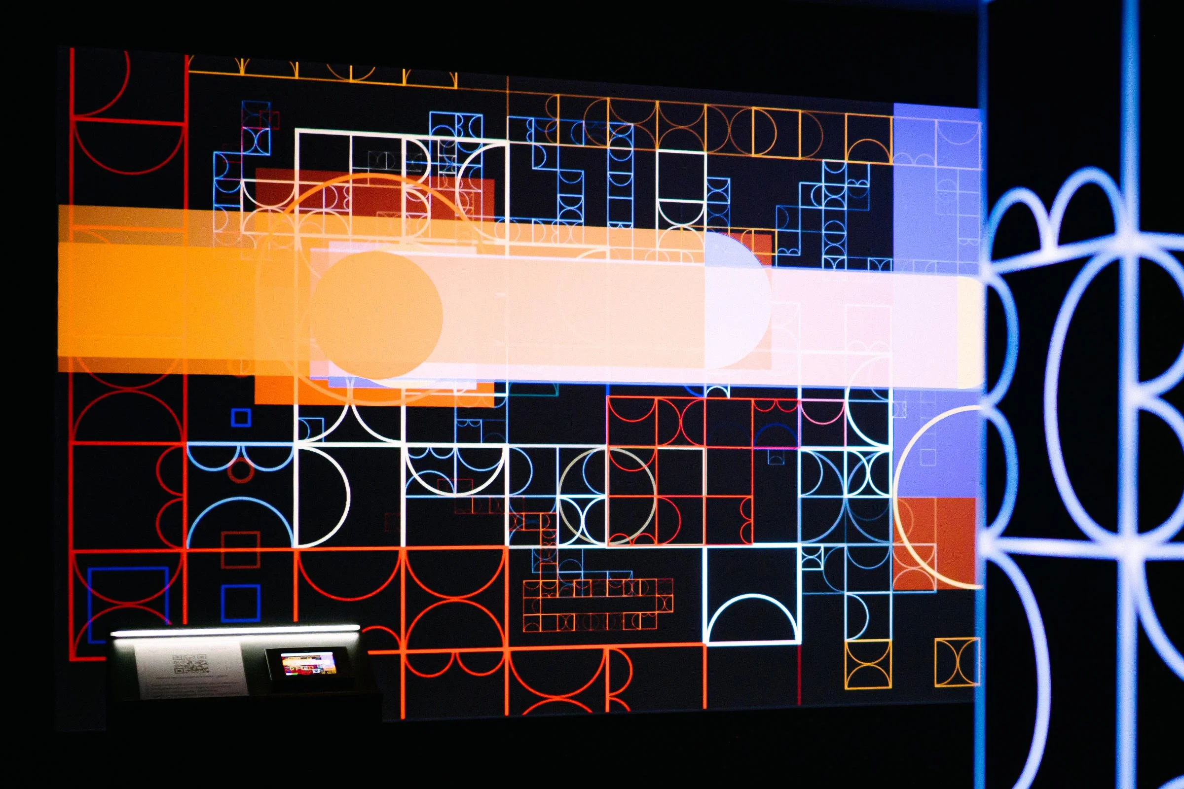 Animated geometric digital painting from shemza.digital #4–7, showing the evolving collaborative artwork projected onto the gallery wall.