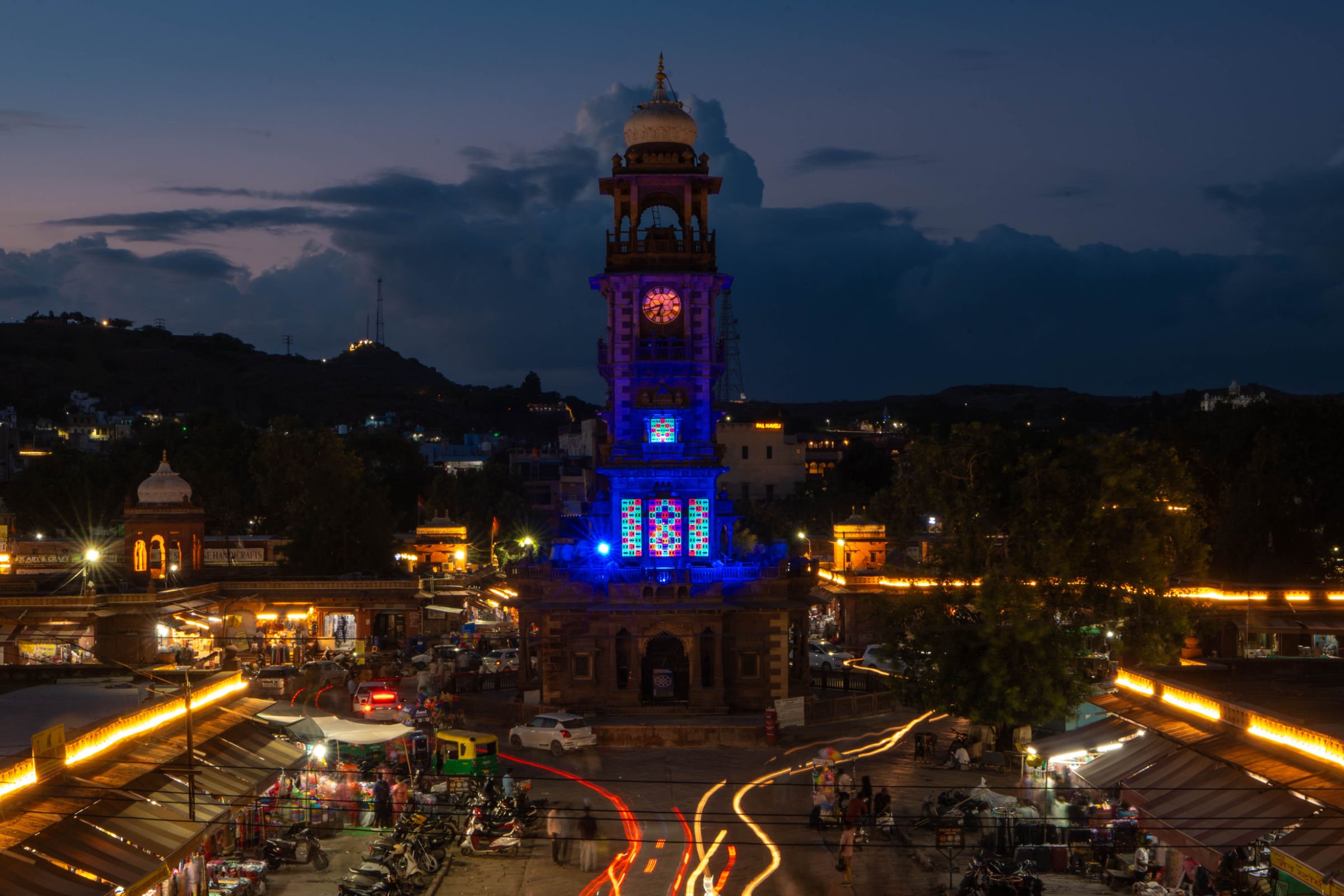 Site-specific fluorescent light installation, shemza.digital #17, installed at the Clock Tower in Sardar Market, Jodhpur, India at twilight.