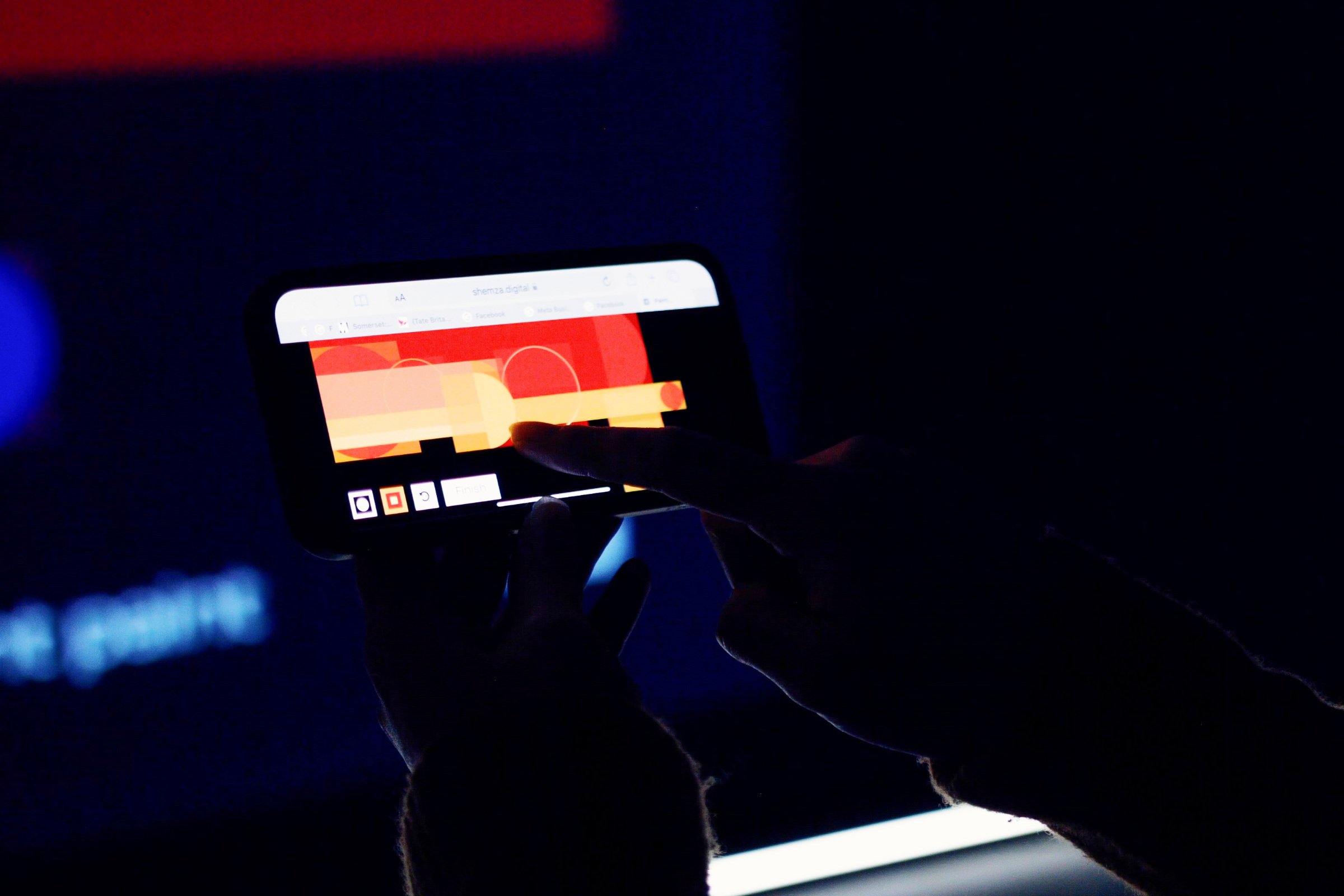 Participant using a mobile phone to create a digital painting for shemza.digital #8, which is instantly added to the live projected archive.