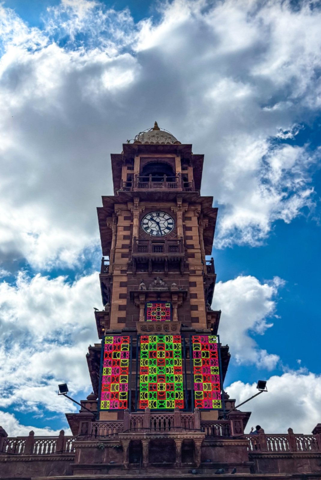 Daylight view of shemza.digital #17 showing fluorescent geometric forms installed at the Clock Tower in Sardar Market, Jodhpur, India.