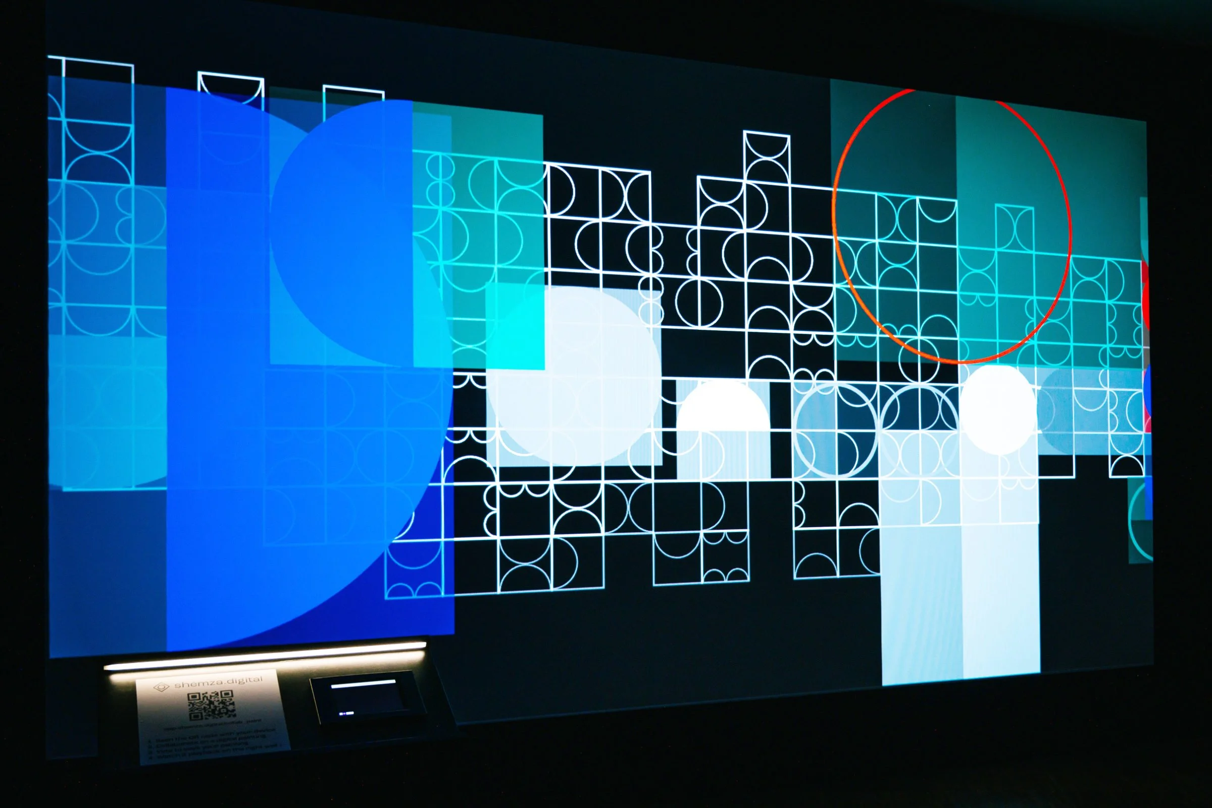 Image of shemza.digital #4–7, an interactive digital artwork featuring a collaborative painting projection with an iPad drawing station in the gallery.