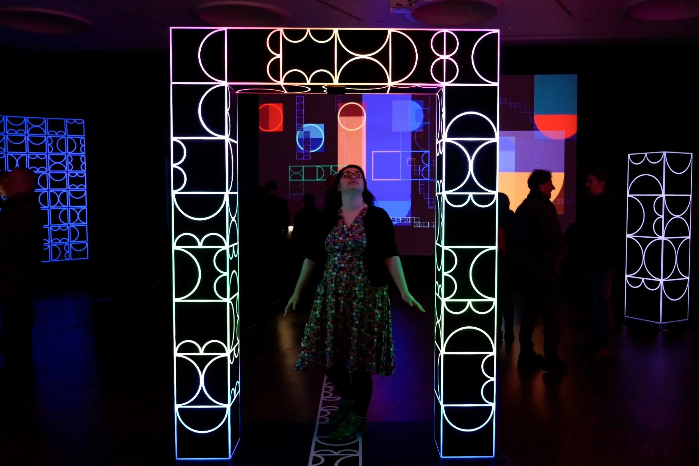 Visitor standing within shemza.digital #5, demonstrating the immersive interactive experience of the illuminated archway.