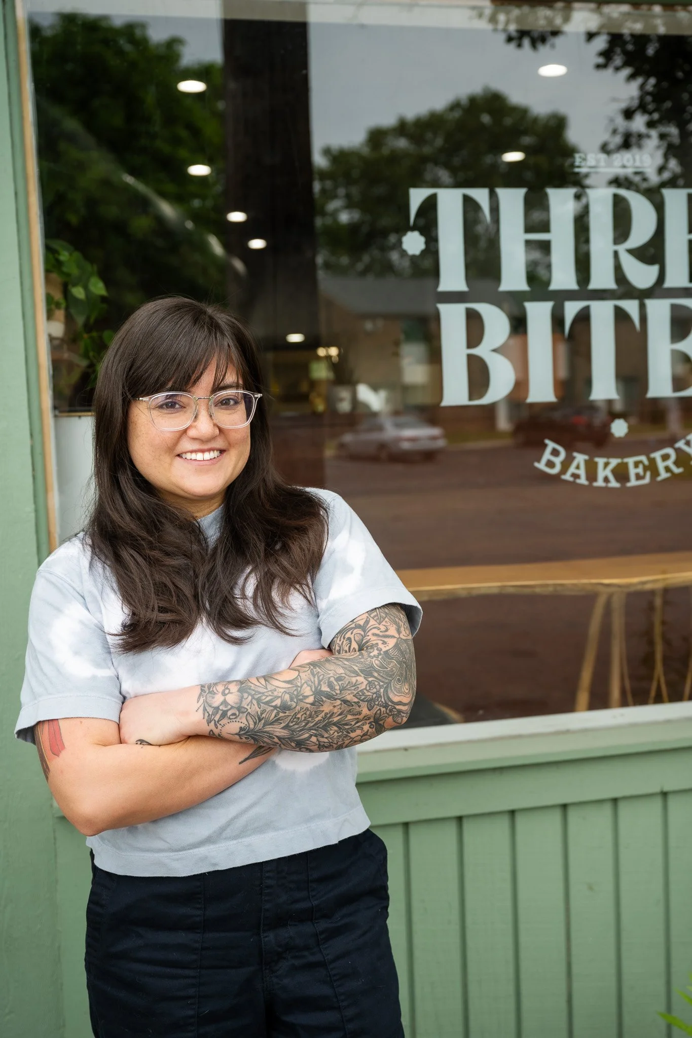 Woman With Arms Crossed In Front of Bakery