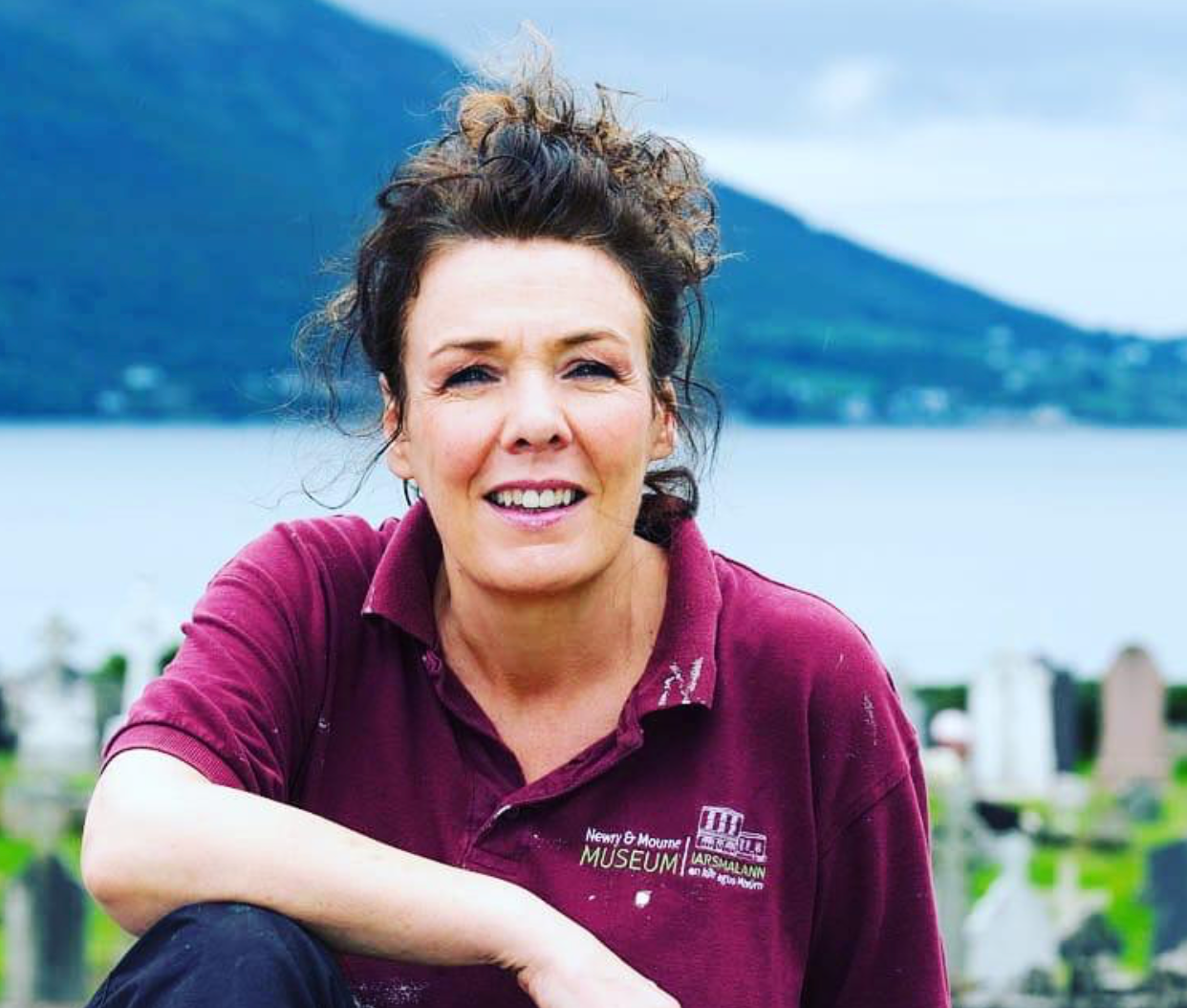 Ann-Marie Savage, sat inf ront of a lake and hills