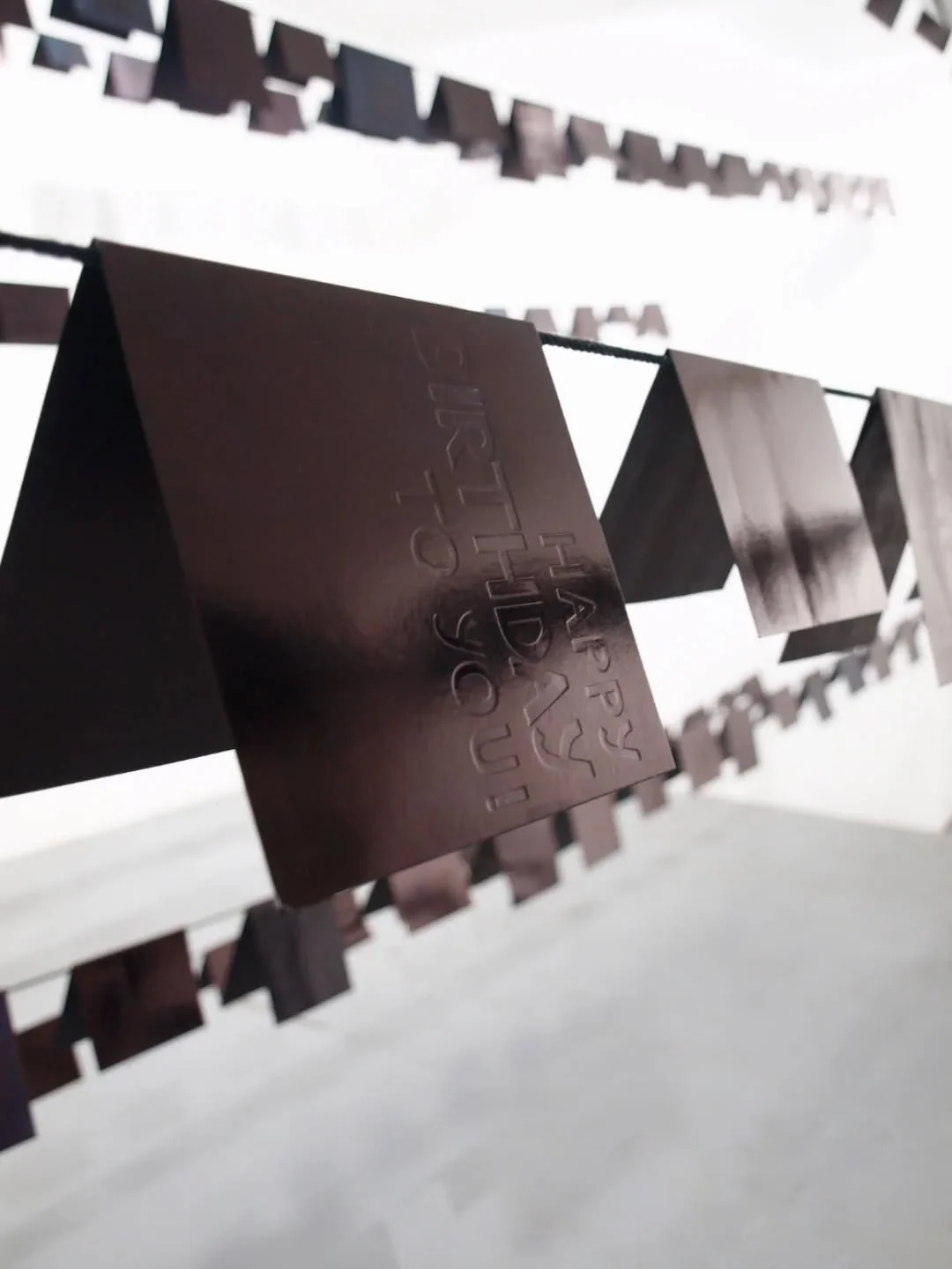 // Issue 65 - Memorabilia //
Artist: Kate McDonnell
@katemcdonnellart
www.katemcdonnell.co.uk
Description: Redacted greetings cards are suspended from cords across a gallery space. What should be a jolly, celebratory scene is sombre. These cards hav