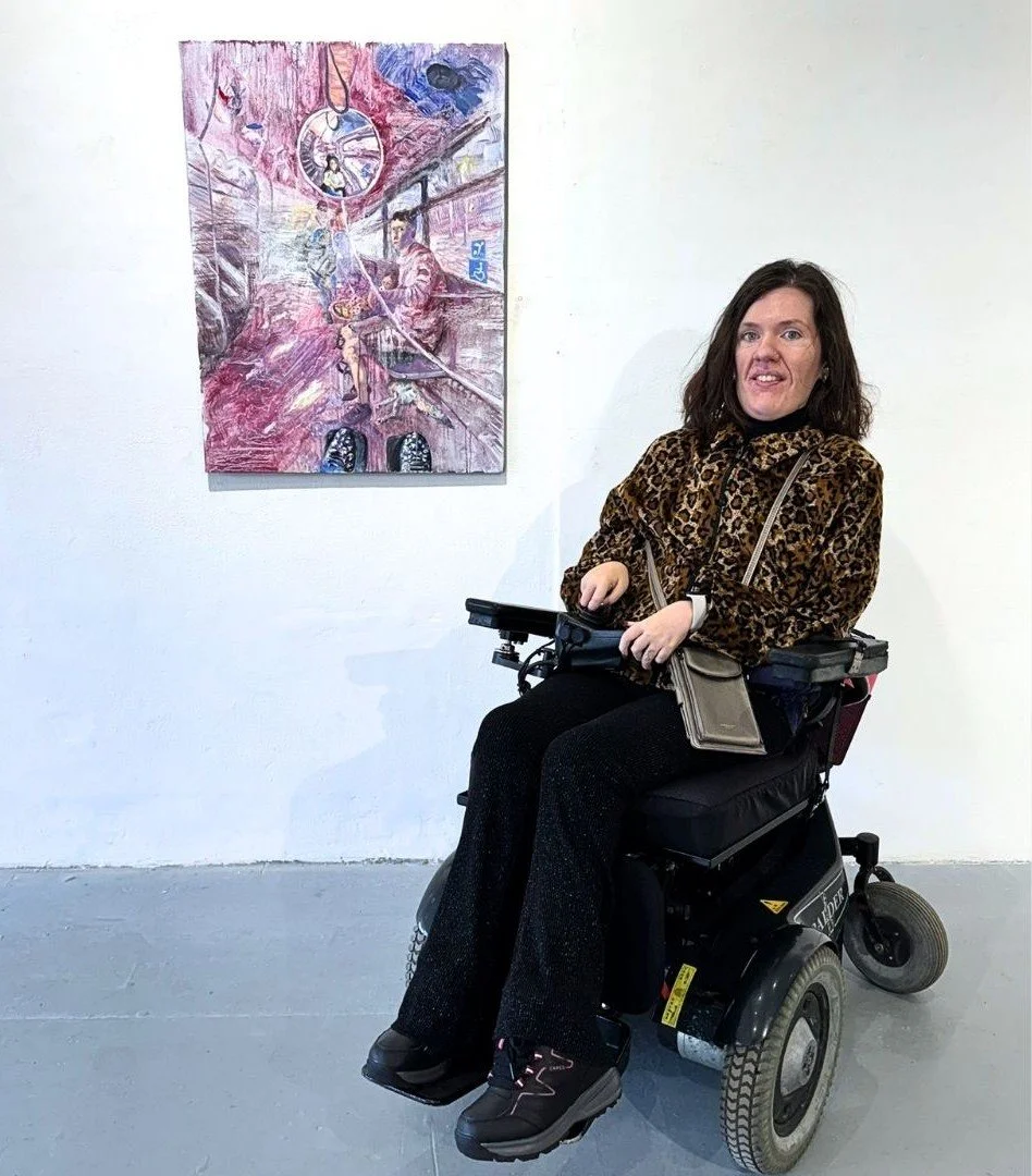 Artist Anna Li, sat in a wheelchair in front of her painting