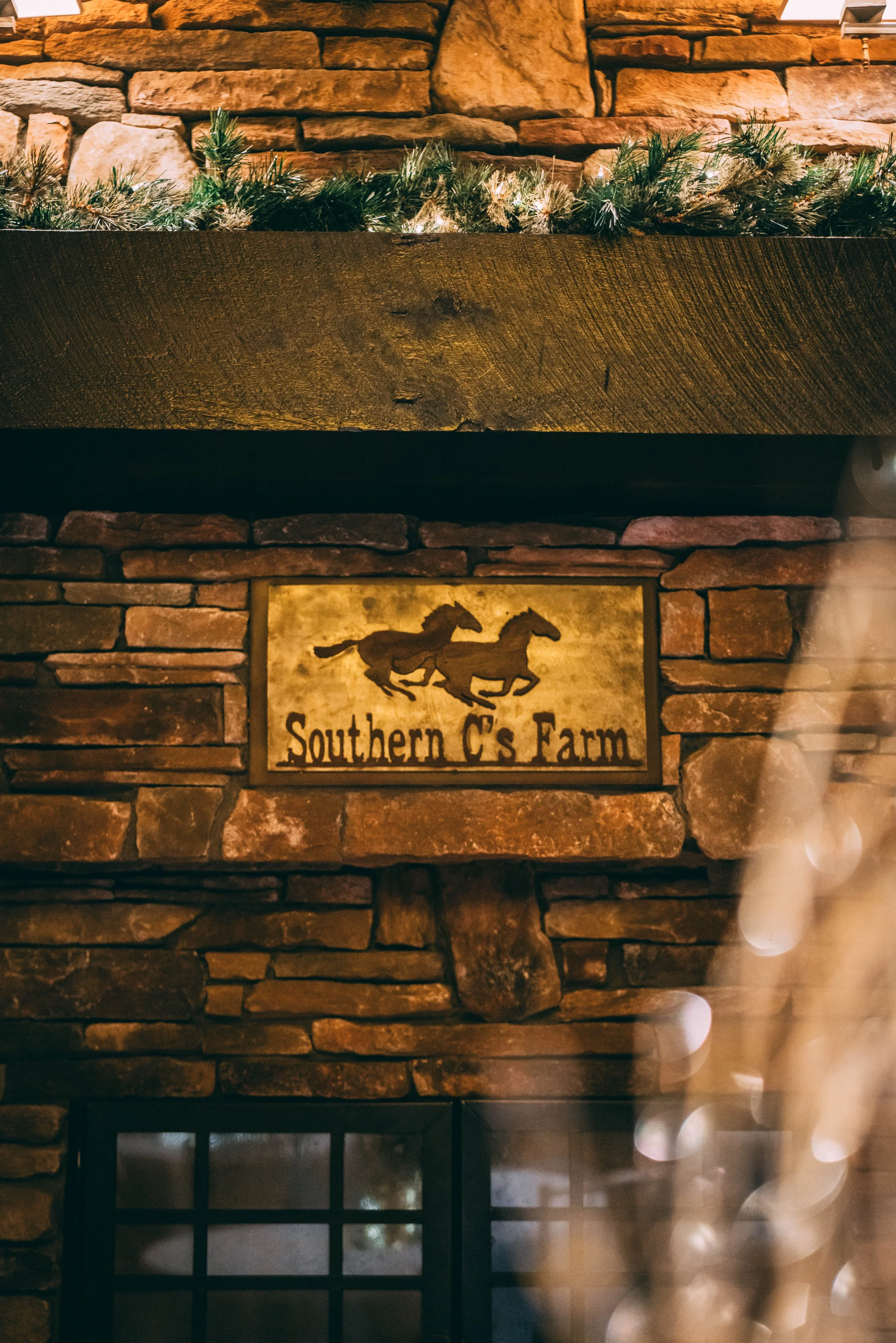 Rustic stone fireplace with festive holiday lighting | Southern C's Farm retreats and gatherings | Greensboro NC area