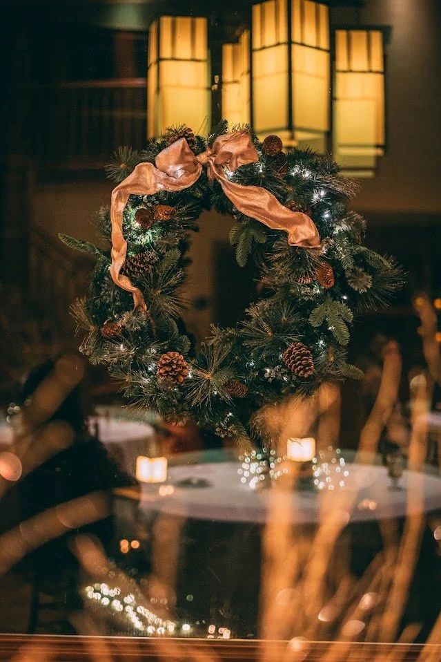 Elegant holiday wreath with pinecones, greenery, and ribbon decor inside Southern C's Farm, perfect for seasonal celebrations and winter gatherings.
