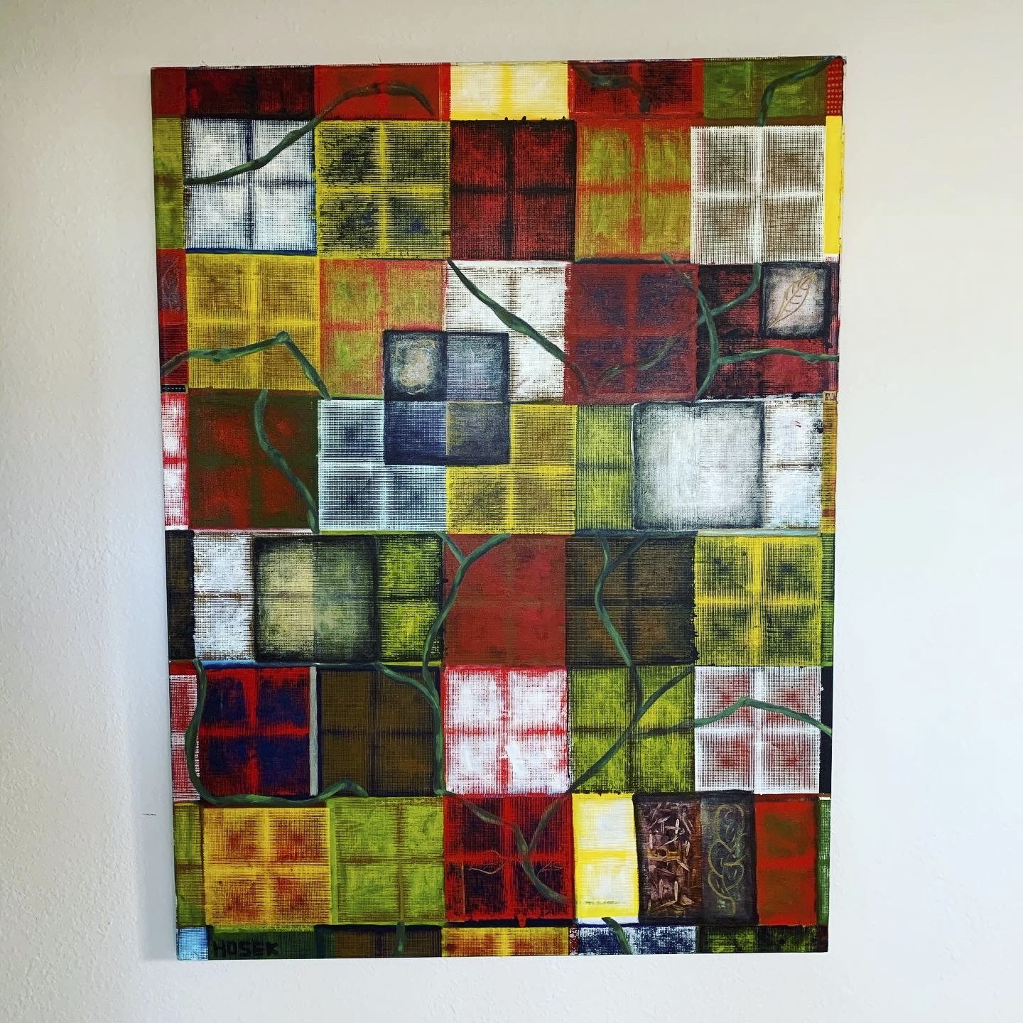 Colorful abstract painting composed of various squares and rectangles in red, yellow, green, blue, black, and white, with some featuring textured and patterned designs, and green vine-like lines crossing through the artwork.