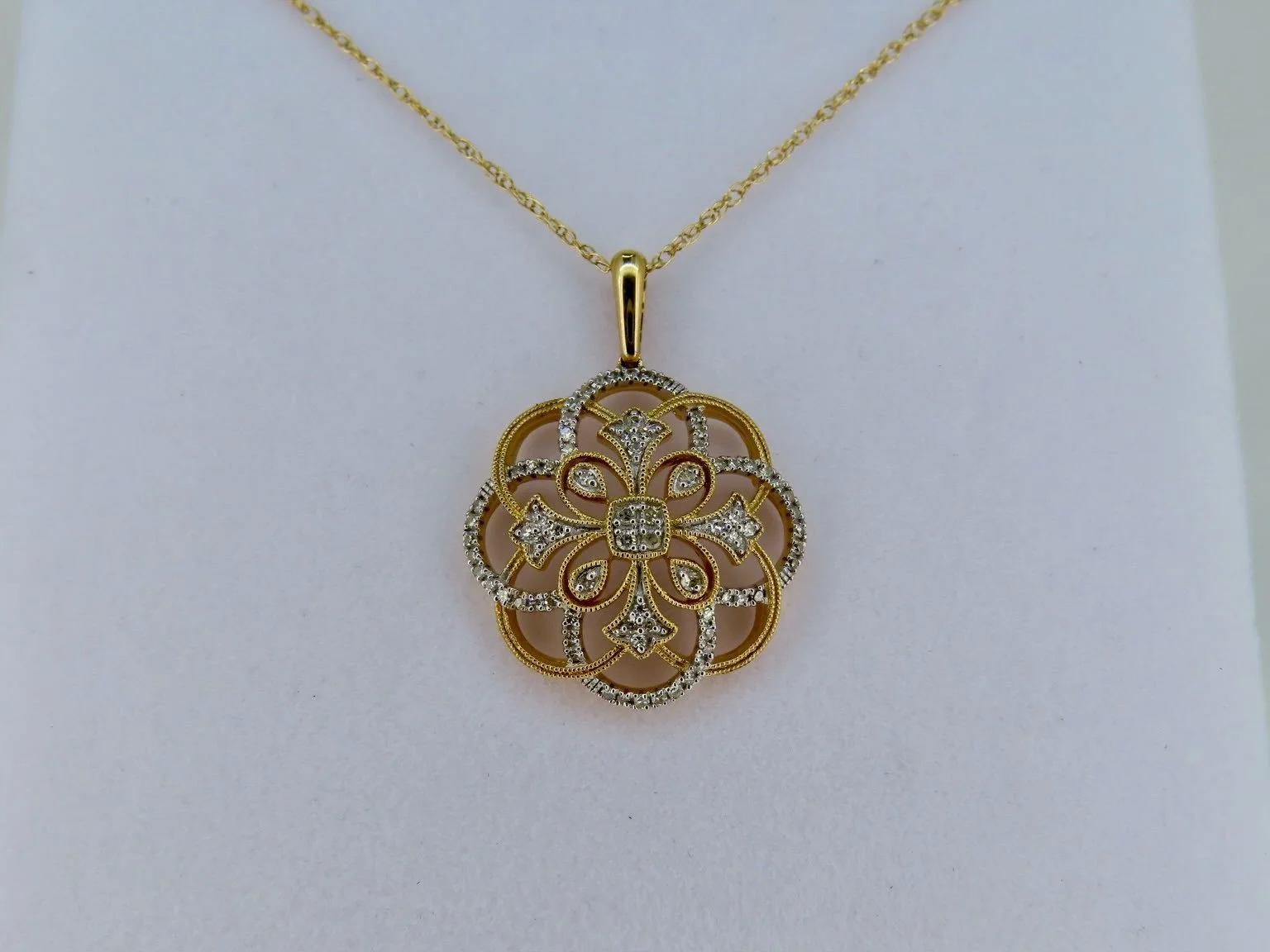 A timeless design with plenty of sparkle: 14K Gold Two-Toned Diamond Filigree Necklace 

This 14K gold two-toned necklace features an intricate openwork medallion pendant, combining contrasting gold and silver tones with delicate scrollwork, textured