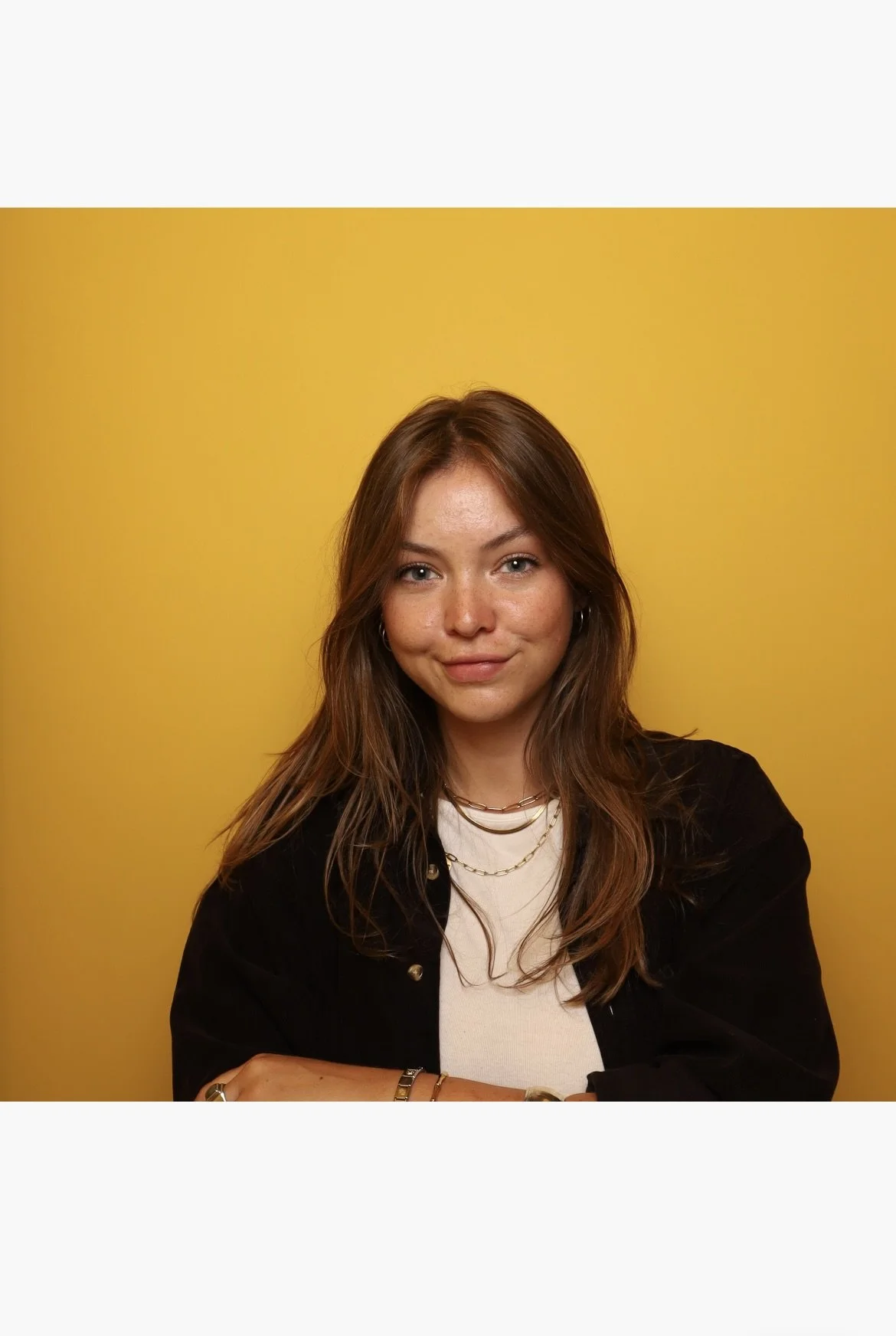 Henrieke in a black shirt and long blond hair,  wearing two necklaces.
