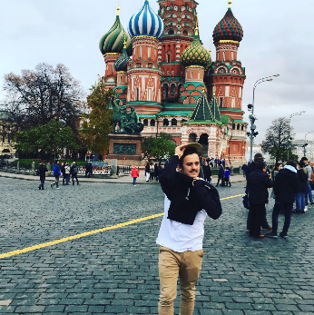 Jeune homme posant en face du basilique Saint-Béatice de Moscou, en Russie.